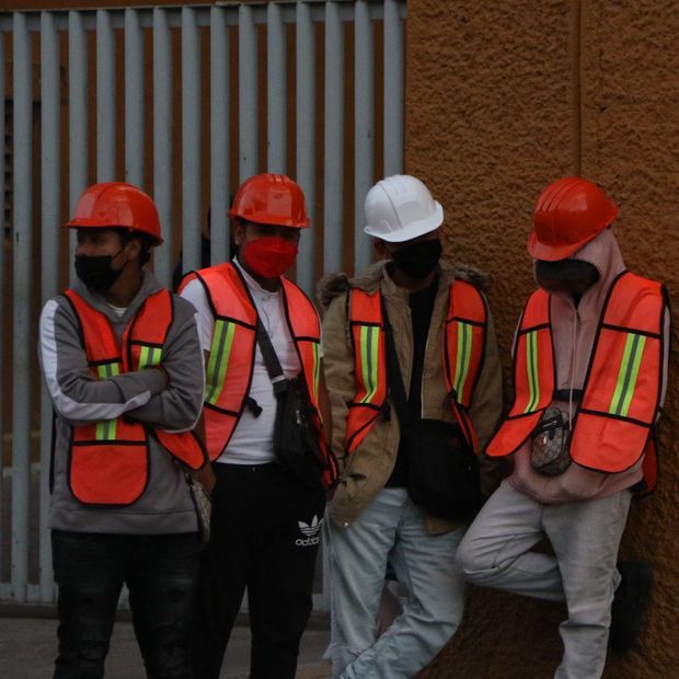 Trabajadores frente a letrero de Salida. 12 de octubre es feriado o se trabaja
