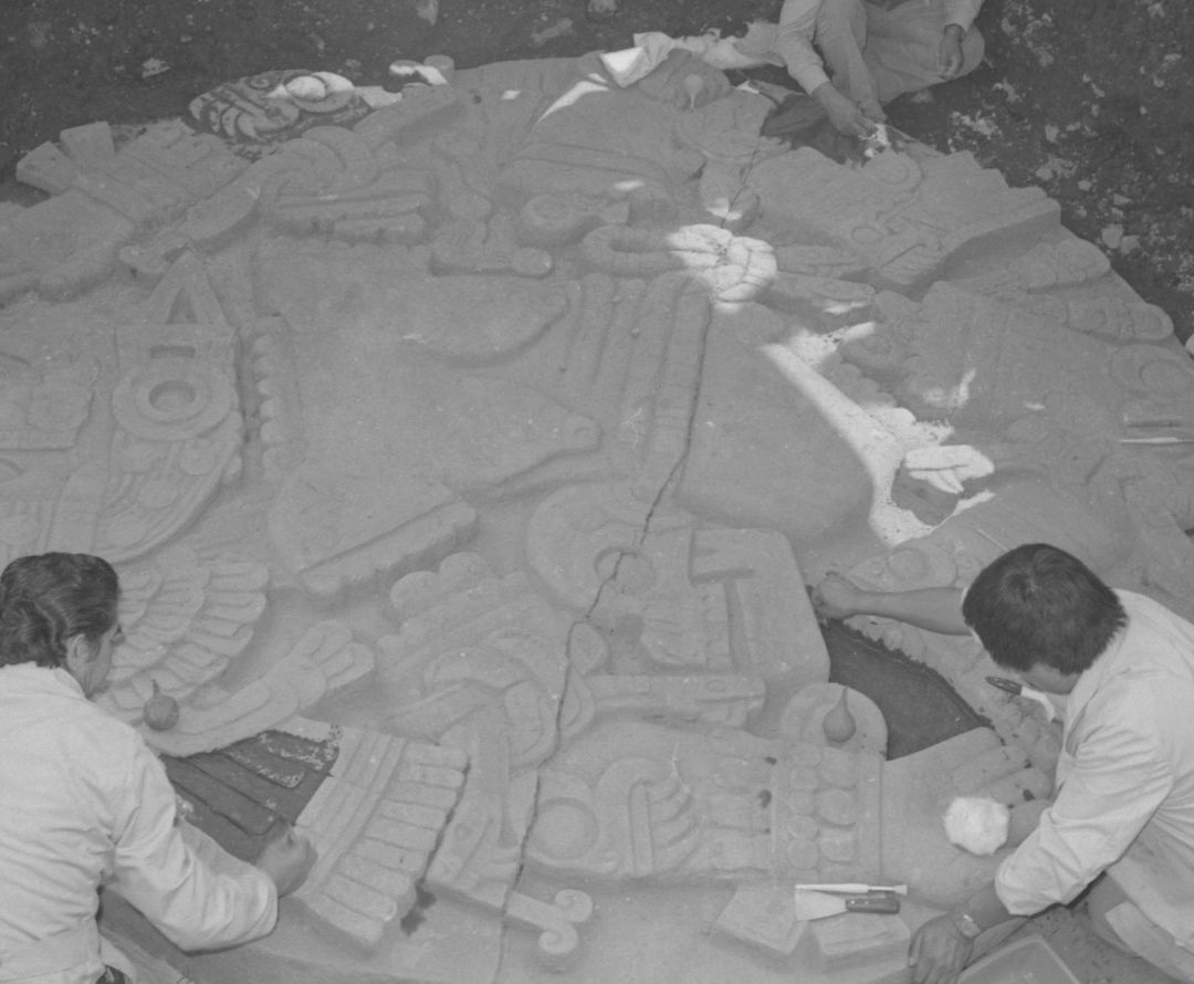 Restauradores trabajan sobre el monolito de Coyolxauhqui tras su hallazgo en 1978, en el Centro Histórico de CDMX