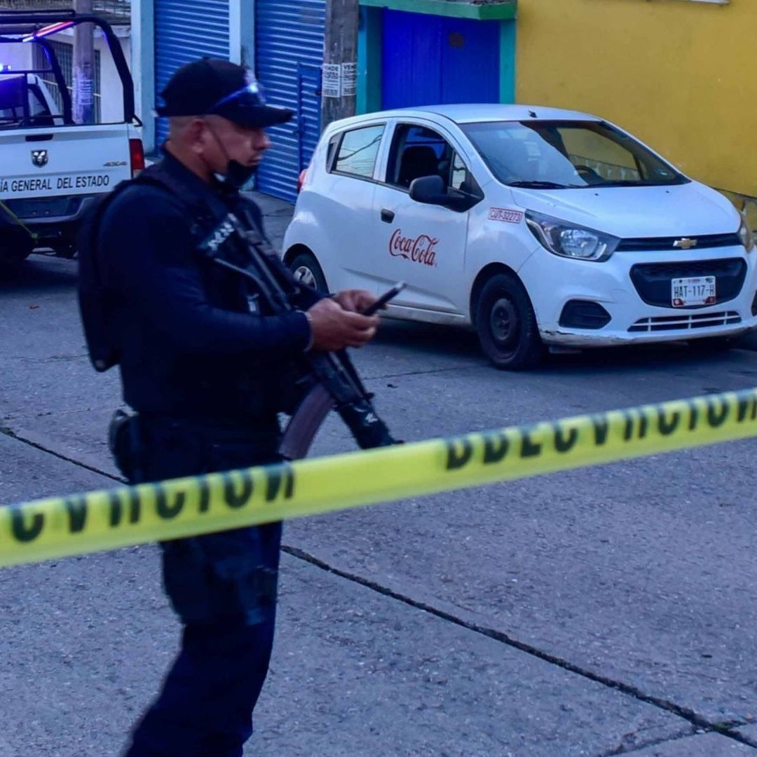 Policías custodian la zona en la que el empleado de una empresa refresquera murió baleado.