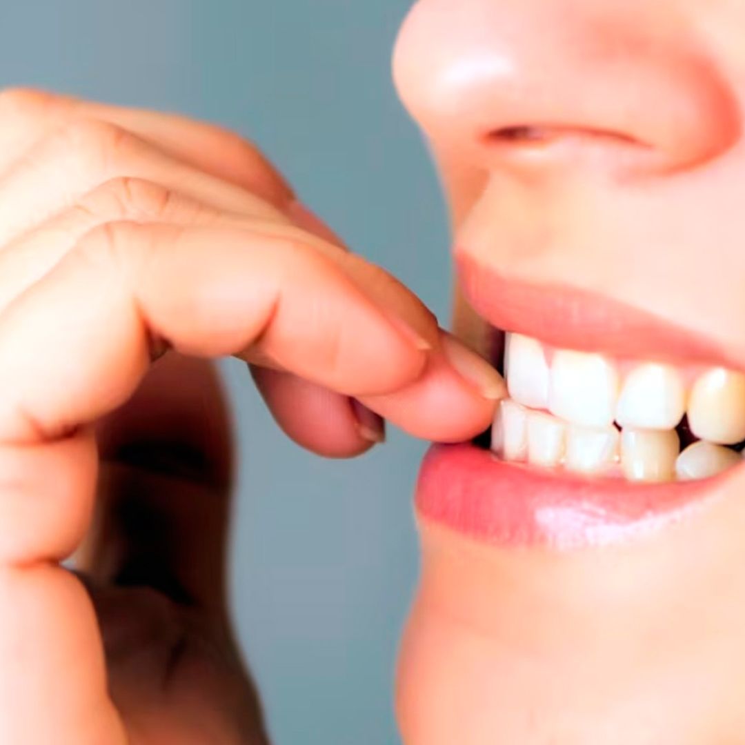Mujer mordiéndose las uñas preocupadamente