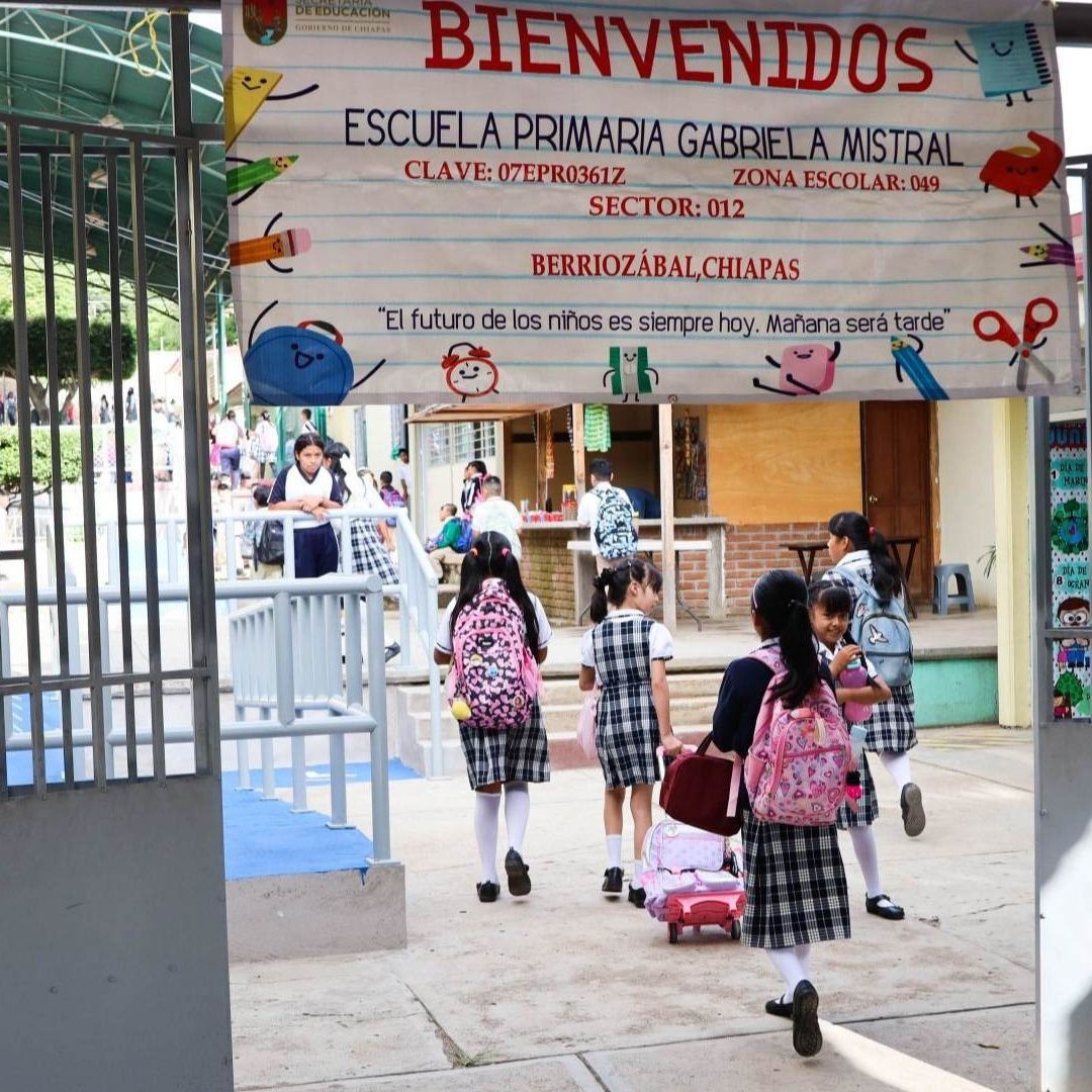 alumnos entran a una escuela primaria pública.
