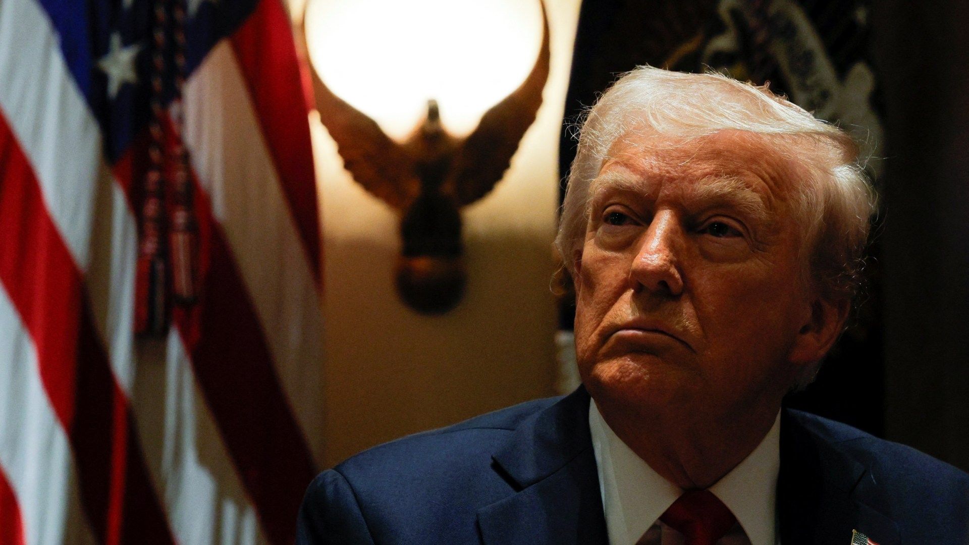 Donald Trump con una bandera de Estados Unidos de fondo