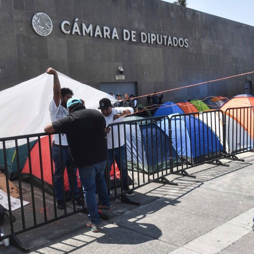 Trabajadores de la CNTE y el SNTE protestan contra la Ley ISSSTE.
