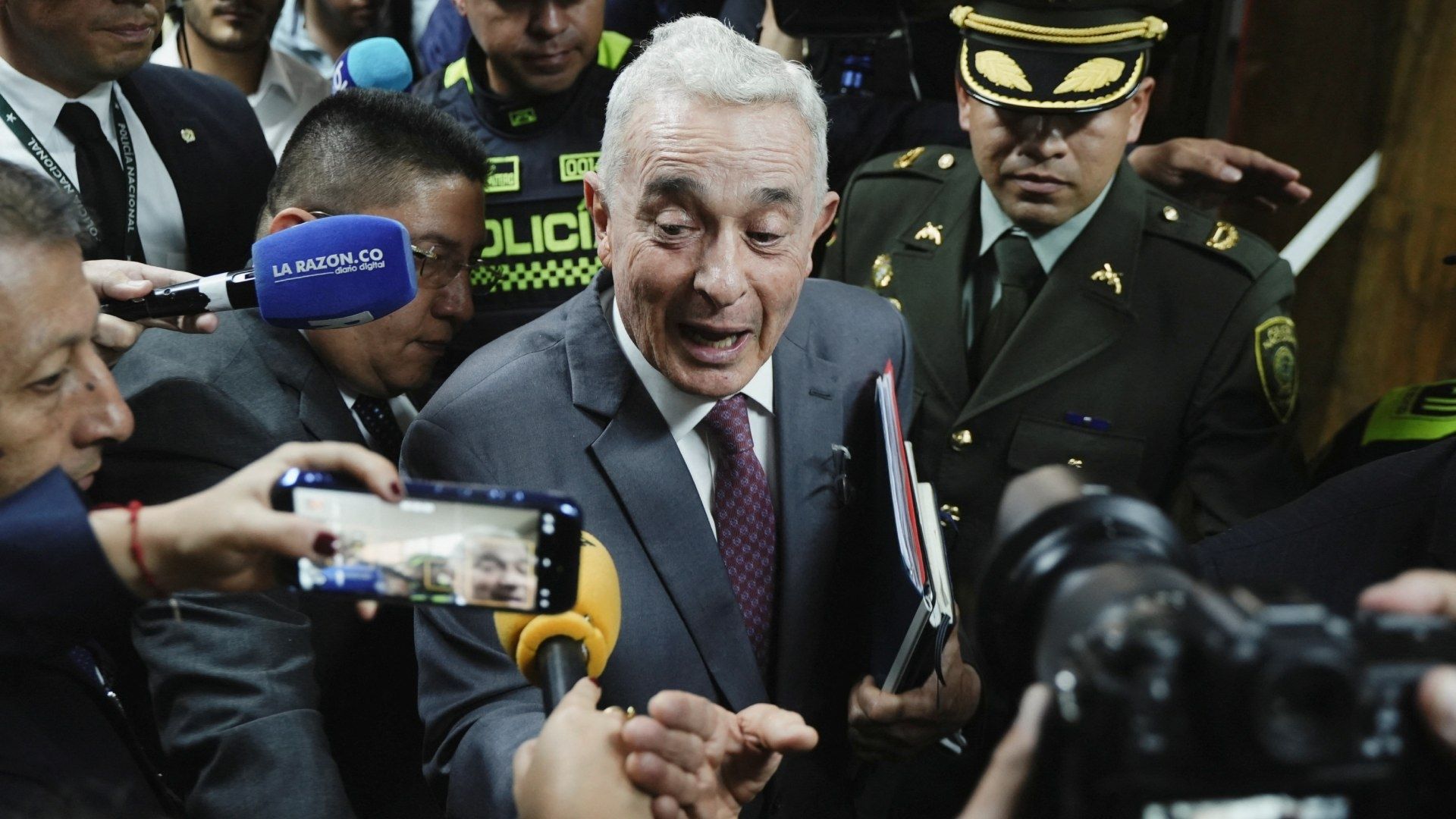 El expresidente colombiano Álvaro Uribe sale del tribunal después de asistir a su primera audiencia de juicio penal.