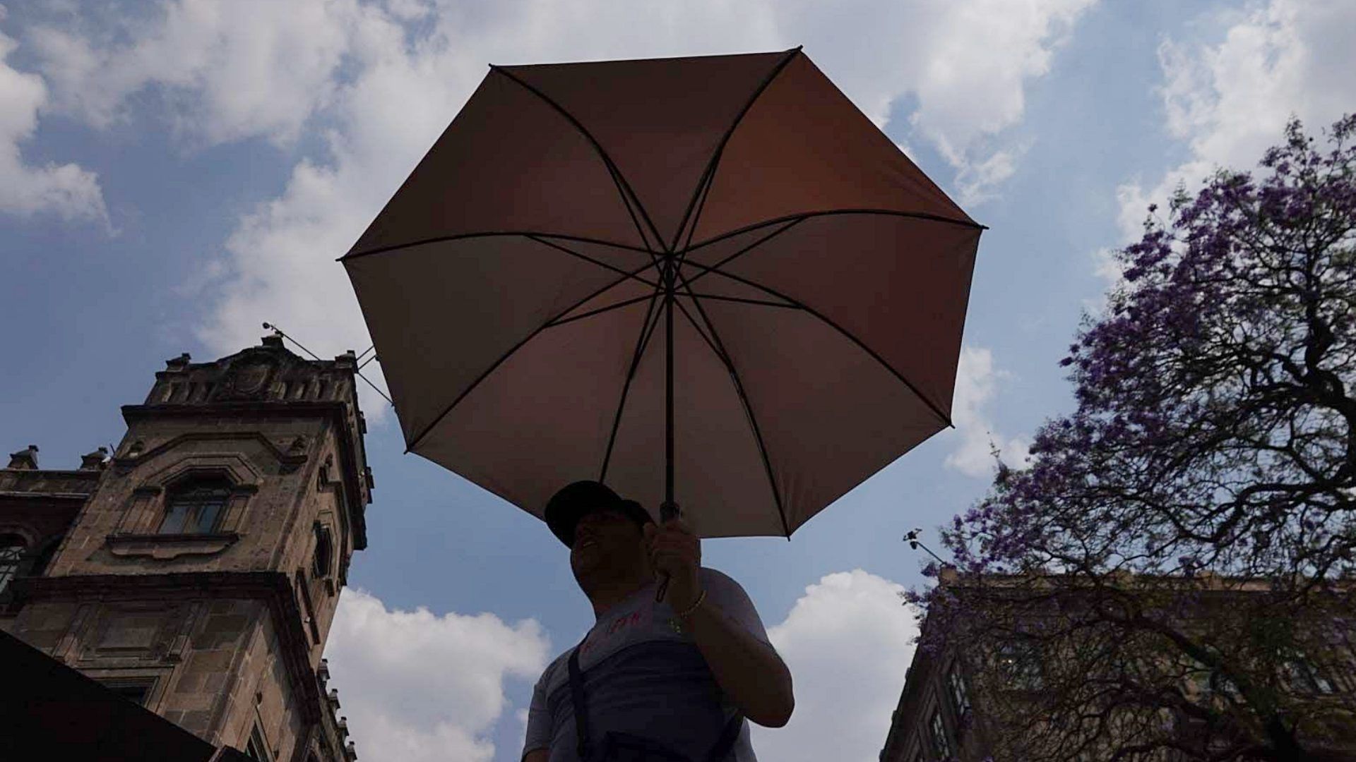Capitalinos se cubren de los rayos del sol en el Zócalo CDMX