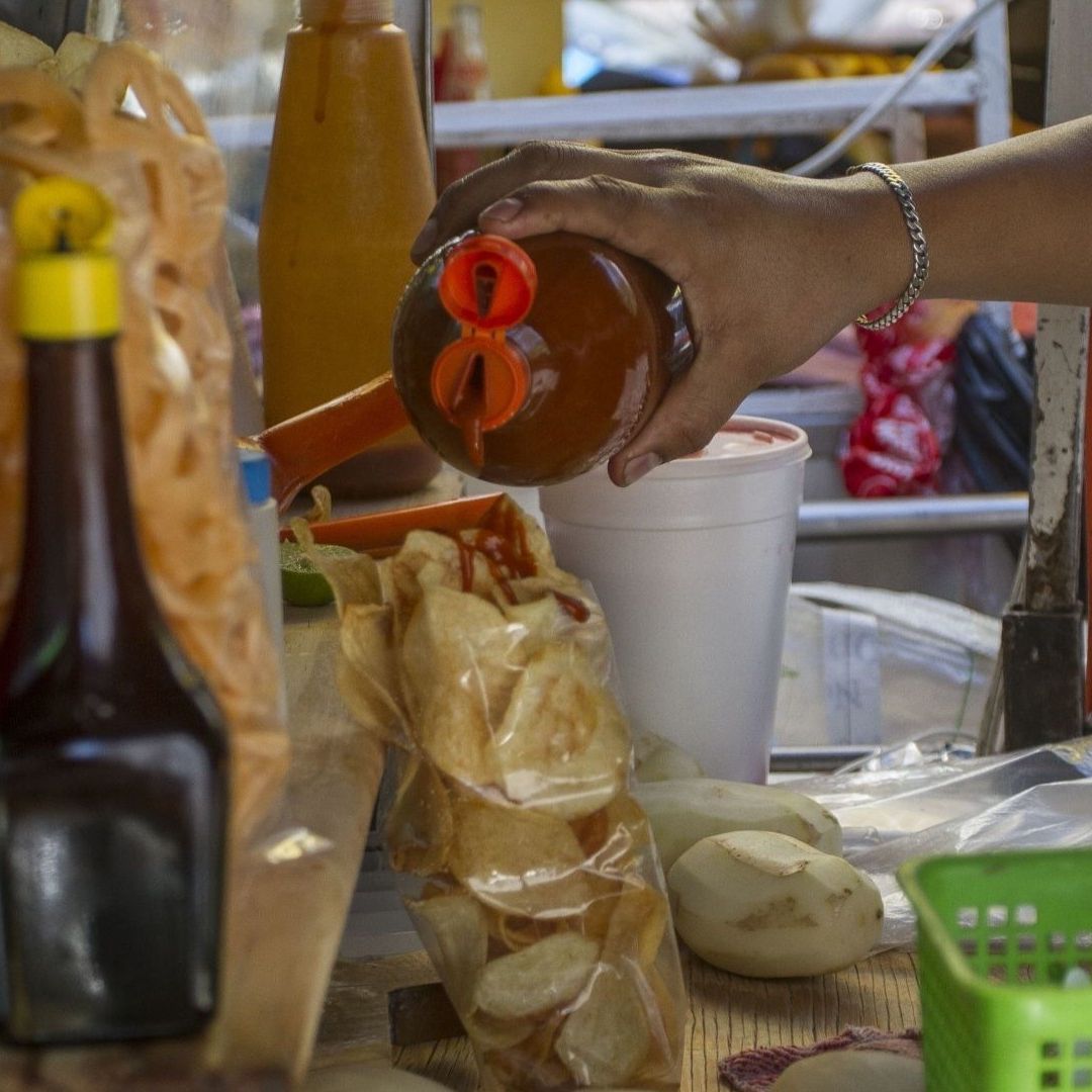 Una persona le pone salsa a una bolsa de papas fritas
