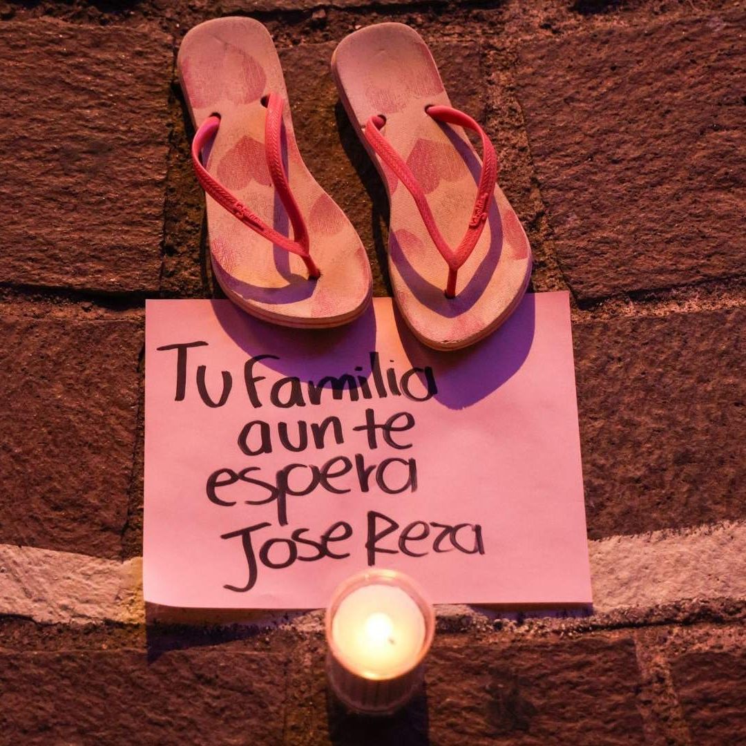 sandalias, una nota y una veladora en memoria de personas desaparecidas