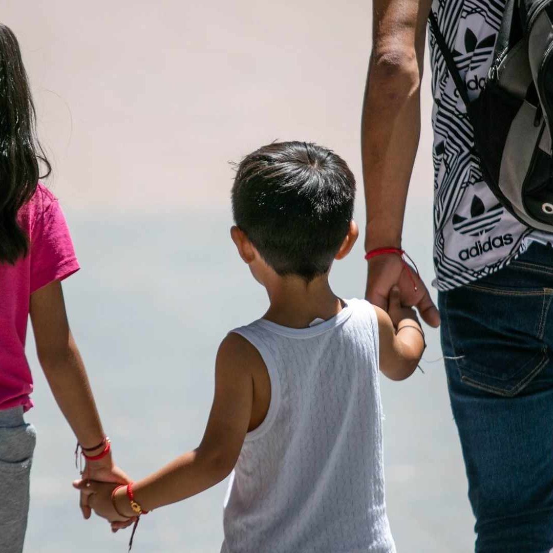 Un padre camina con sus hijos