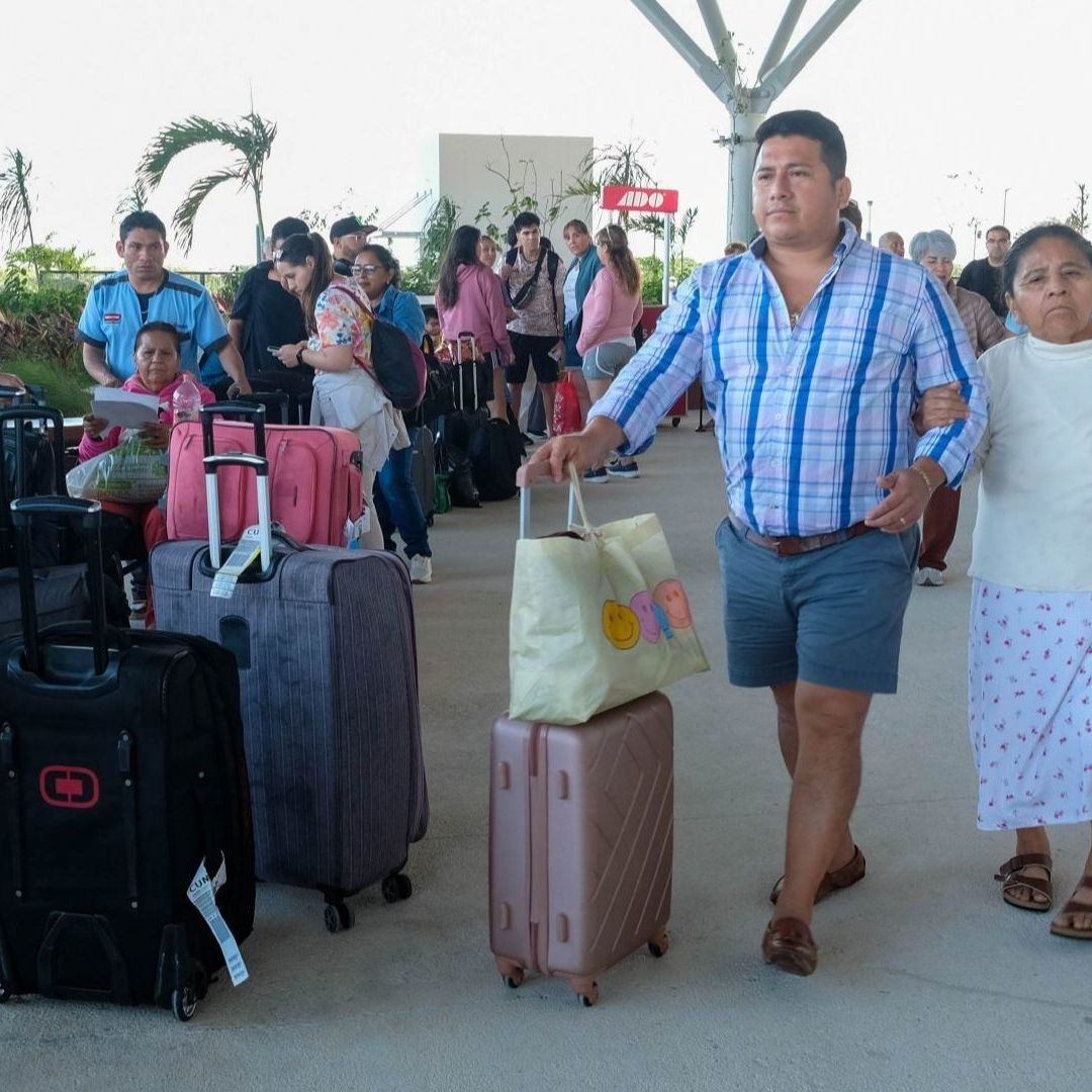 personas turistas caminan en estación del Tren Maya