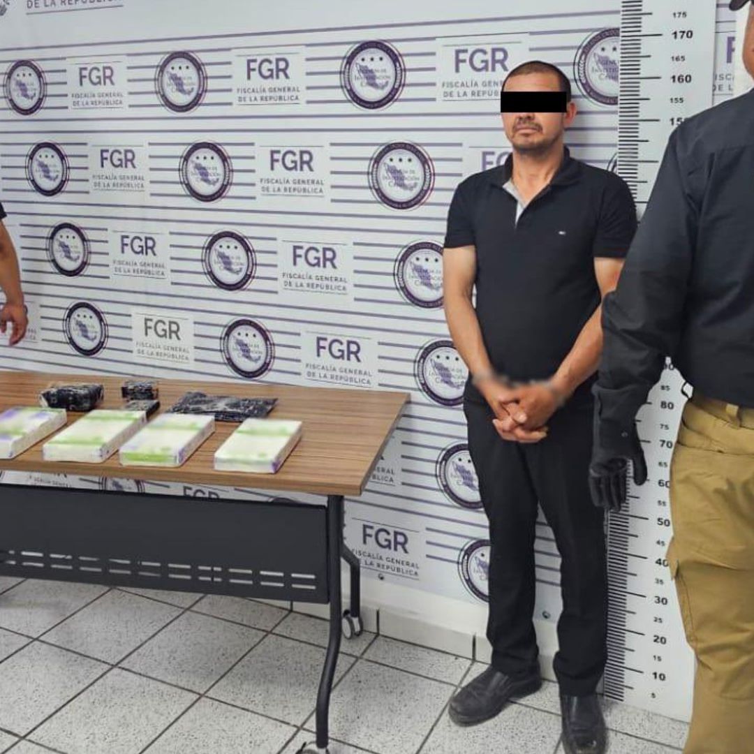 Policías flanquean a hombre detenido por narcotráfico
