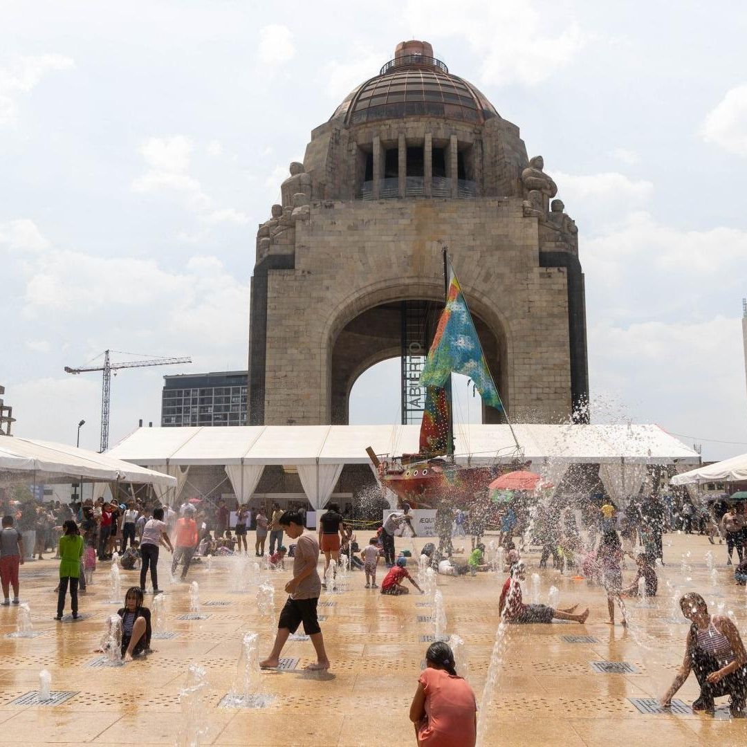 Niños se refrescan en las fuentes del Monumento a la Revolución, en CDMX