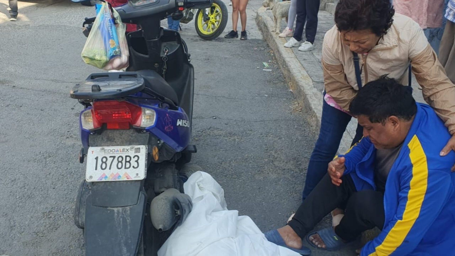 Personas observan el cuerpo de la mujer asesinada en Ecatepec