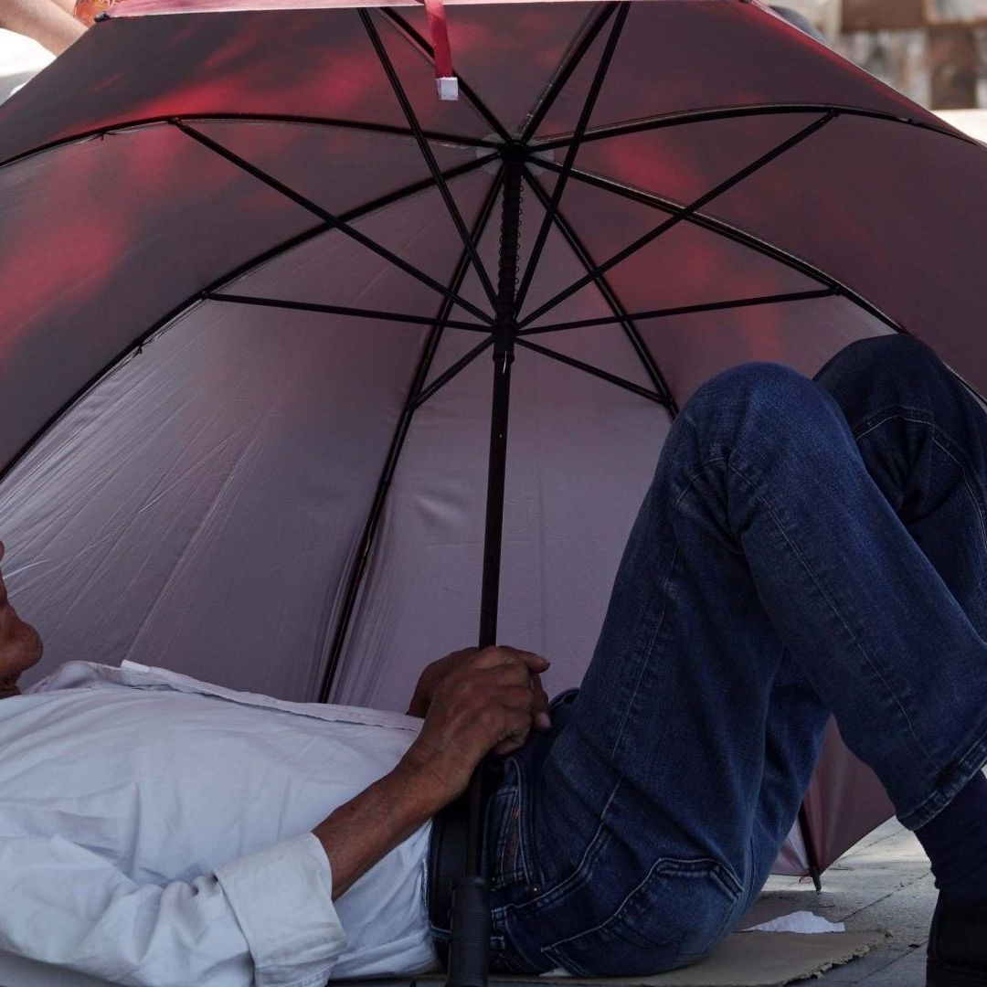 Hombre se cubre de los rayos del sol en la Alameda Central de la CDMX