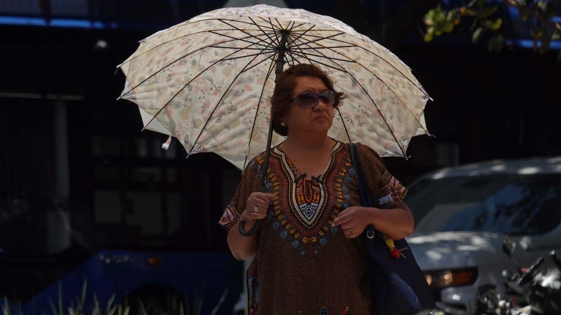 Una mujer se protege de los rayos del Sol en la Alameda Central