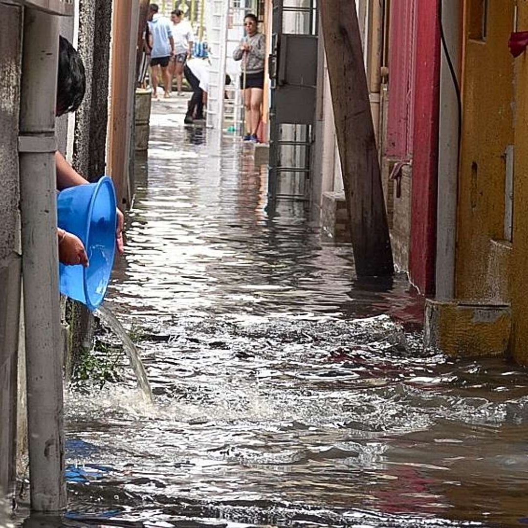 Vecinos de la colonia Ejército de Oriente, Iztapalapa, sacan el agua de sus casas tras lluvia el 3 de junio de 2025