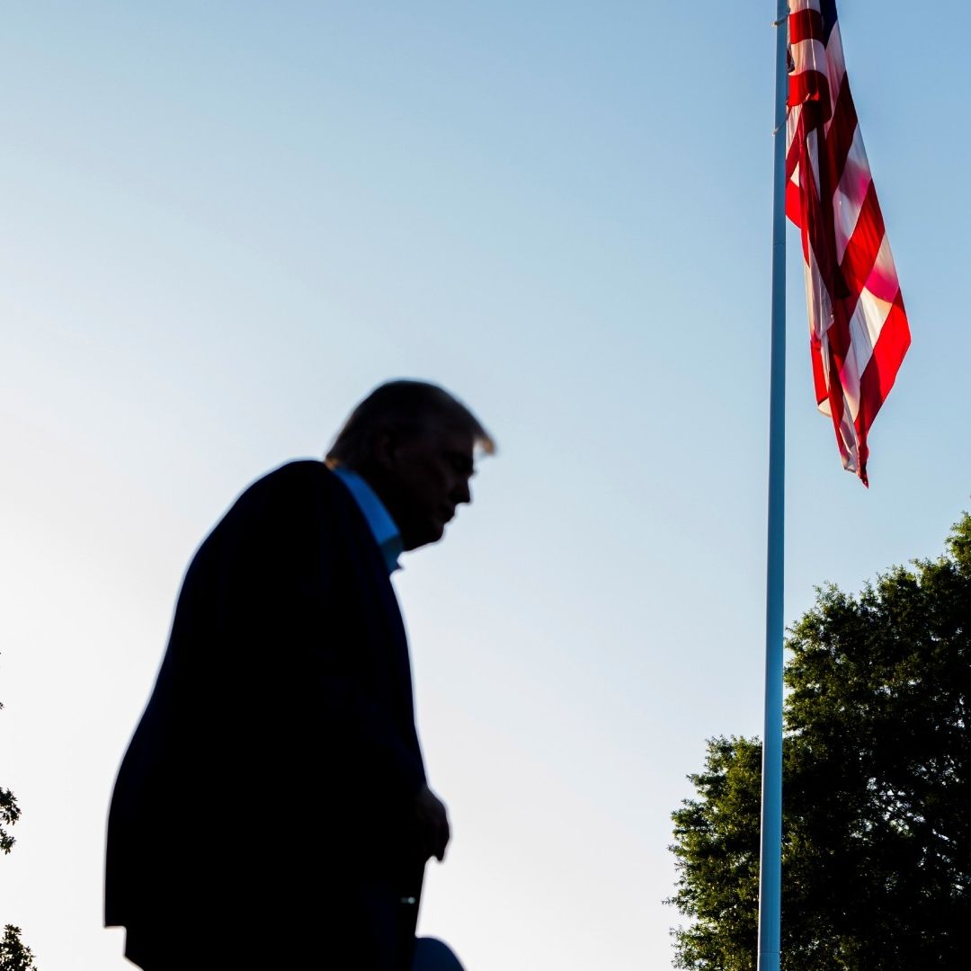 Donald Trump camina frente a bandera de Estados Unidos