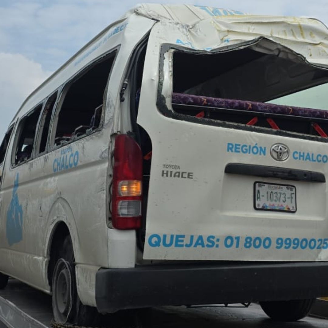 Combi destruida luego de accidente, sobre una plataforma de grúa