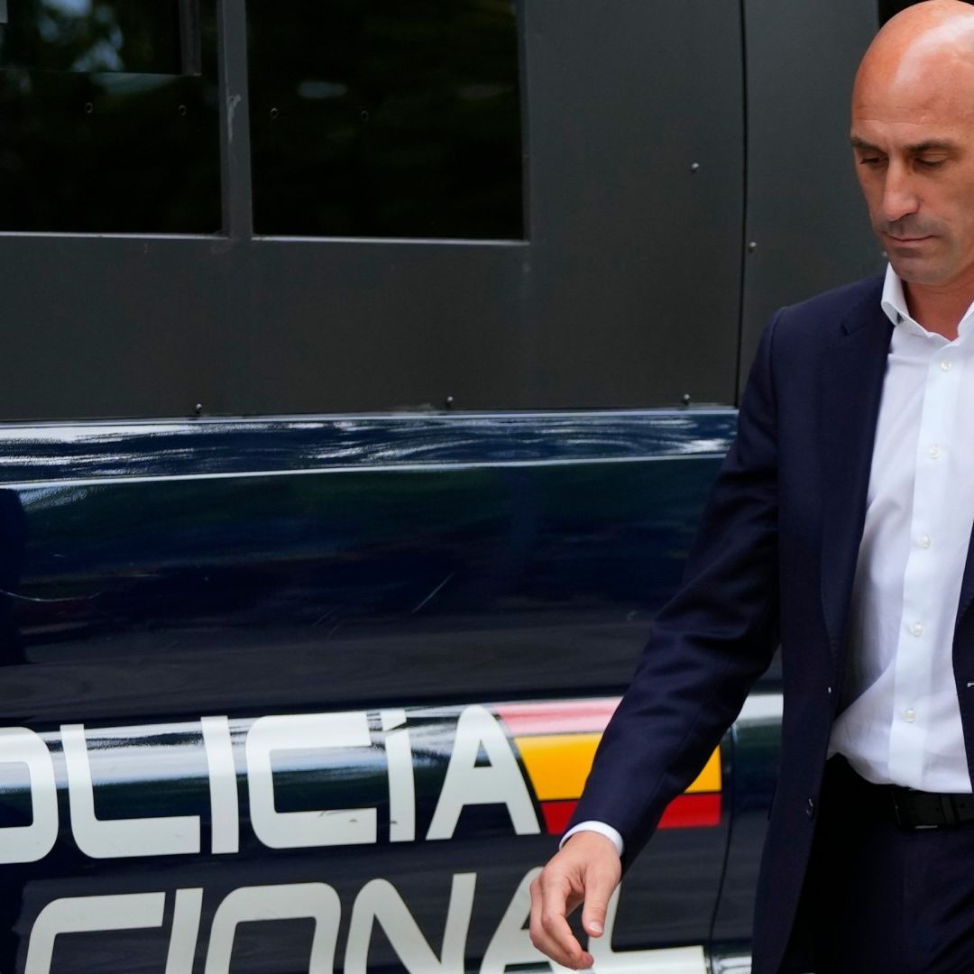 Luis Rubiales camina cerca de una patrulla de la Policía Nacional