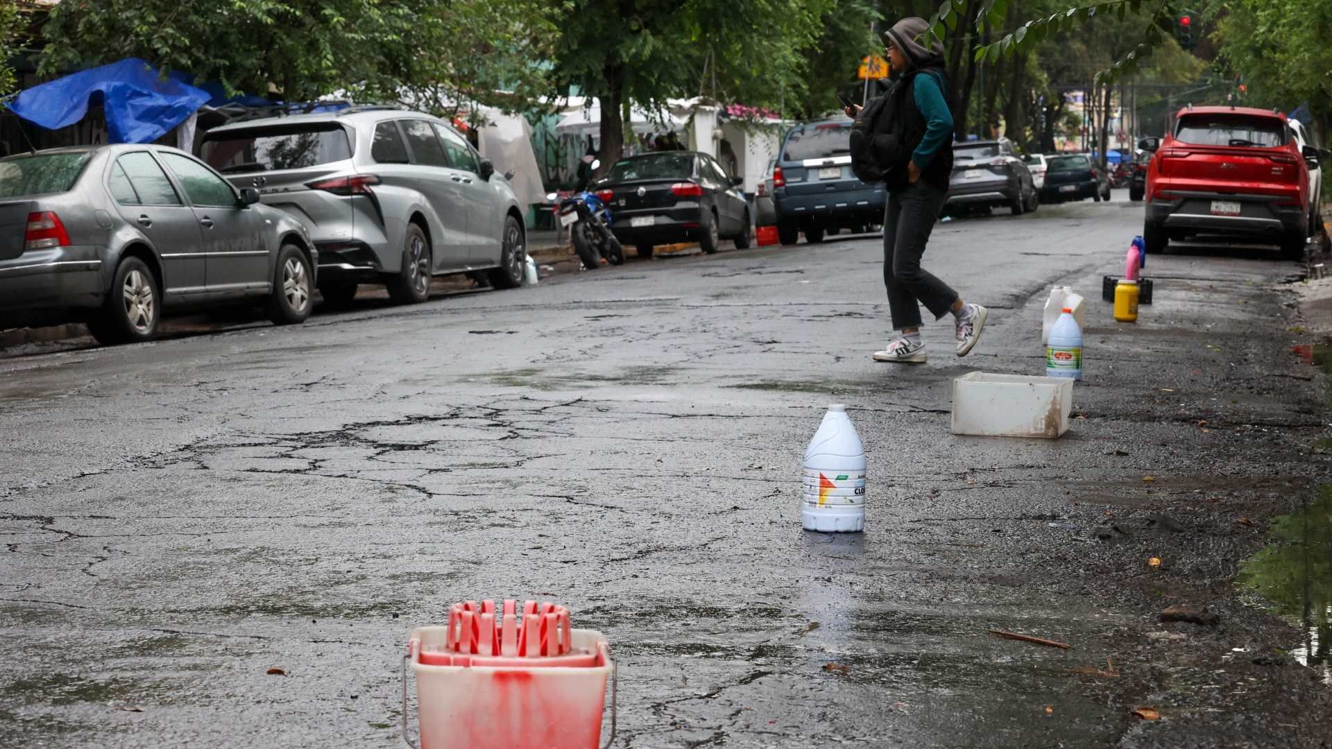 Personas que apartan lugares en las calles usan botes de plástico para que ciudadanos no se estacionen