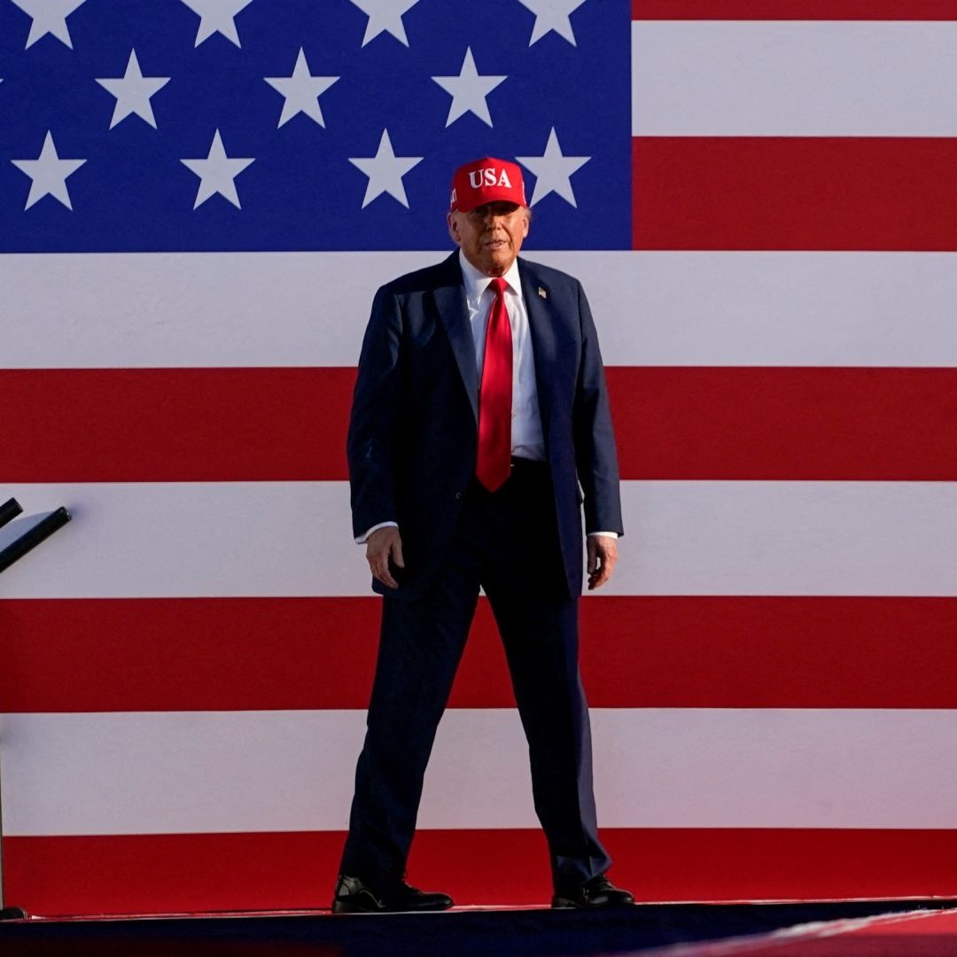 Donald Trump camina frente a bandera de Estados Unidos