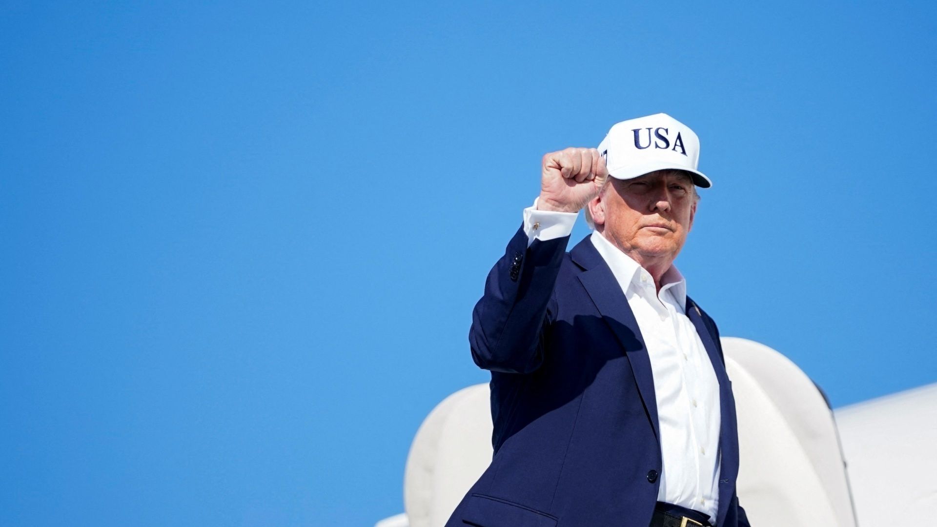 Donald Trump saluda antes de subir a un avión