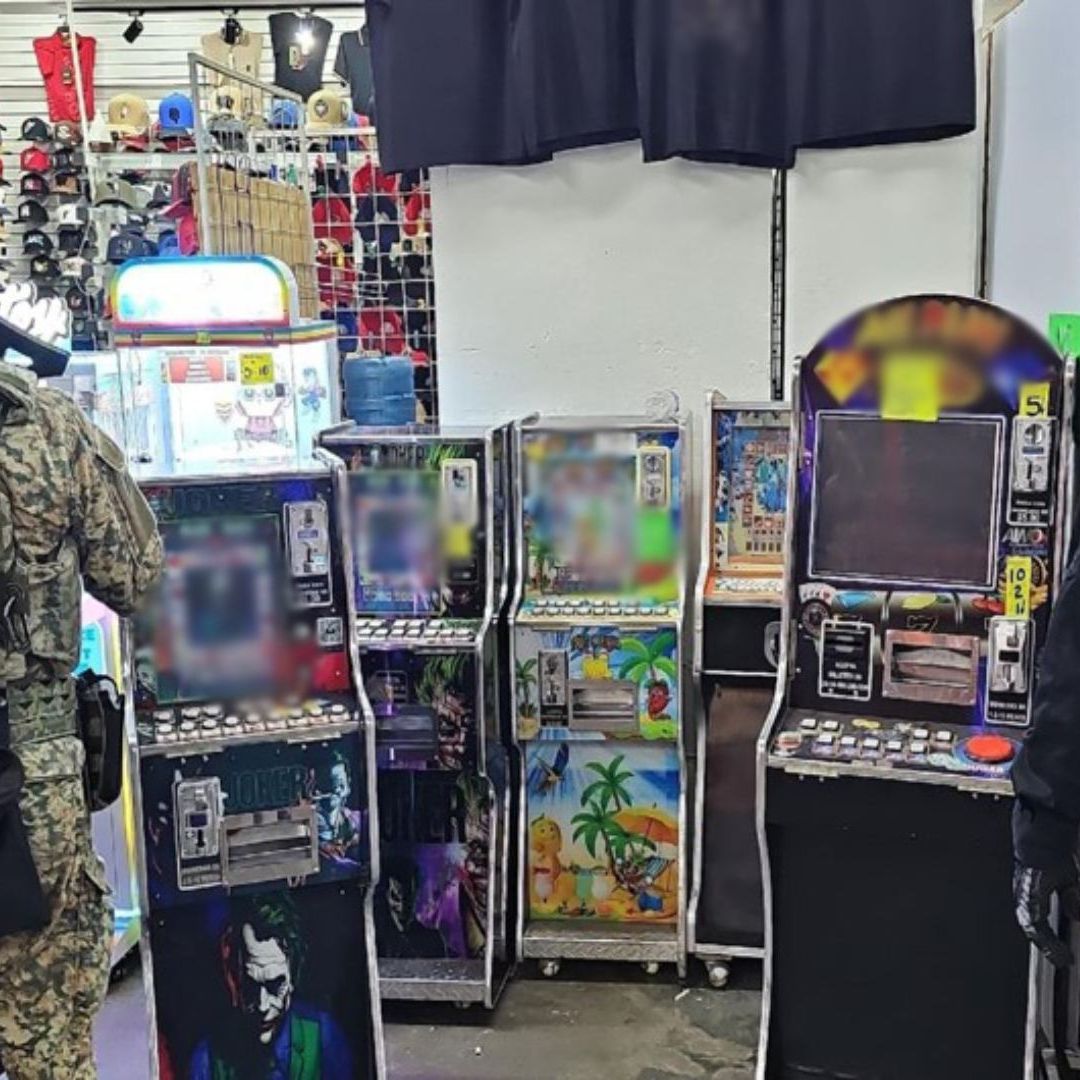 Autoridades frente a máquinas tragamonedas en un local comercial
