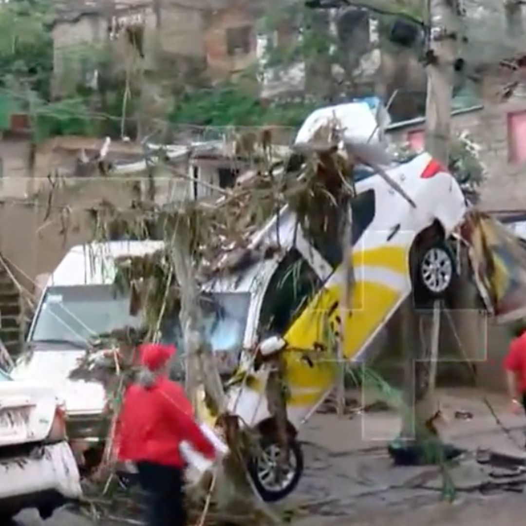 Taxi queda colgando en poste luego de inundaciones en Zapopan