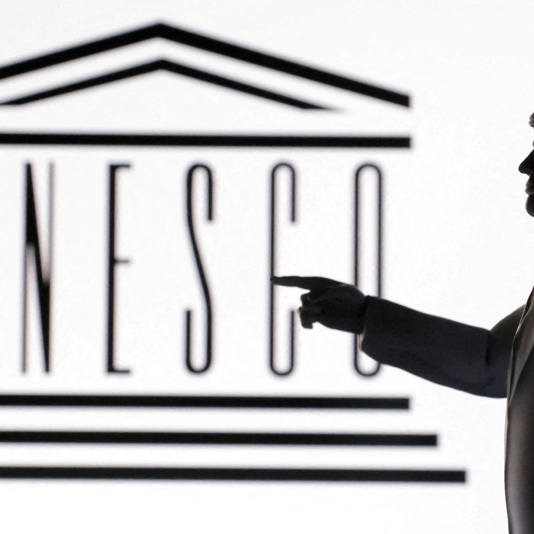 Figura impresa de Donald Trump apunta hacia el logotipo de la UNESCO