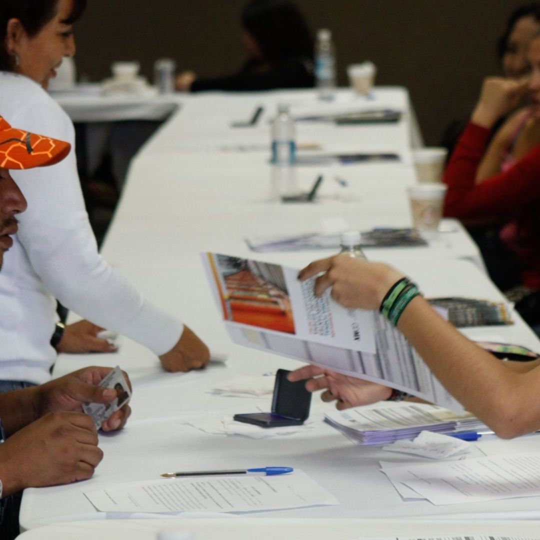 Personas sentadas en mesa durante solicitud de trámite