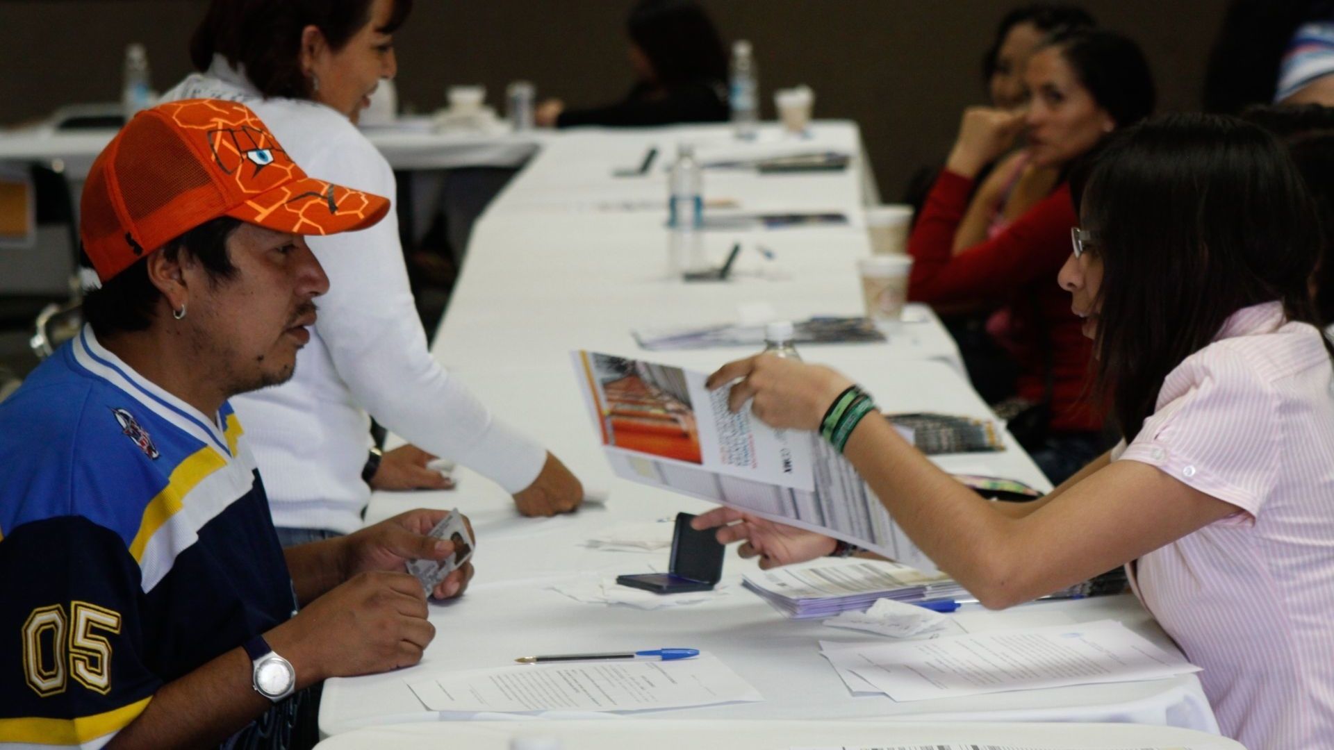Personas sentadas en mesa durante solicitud de trámite