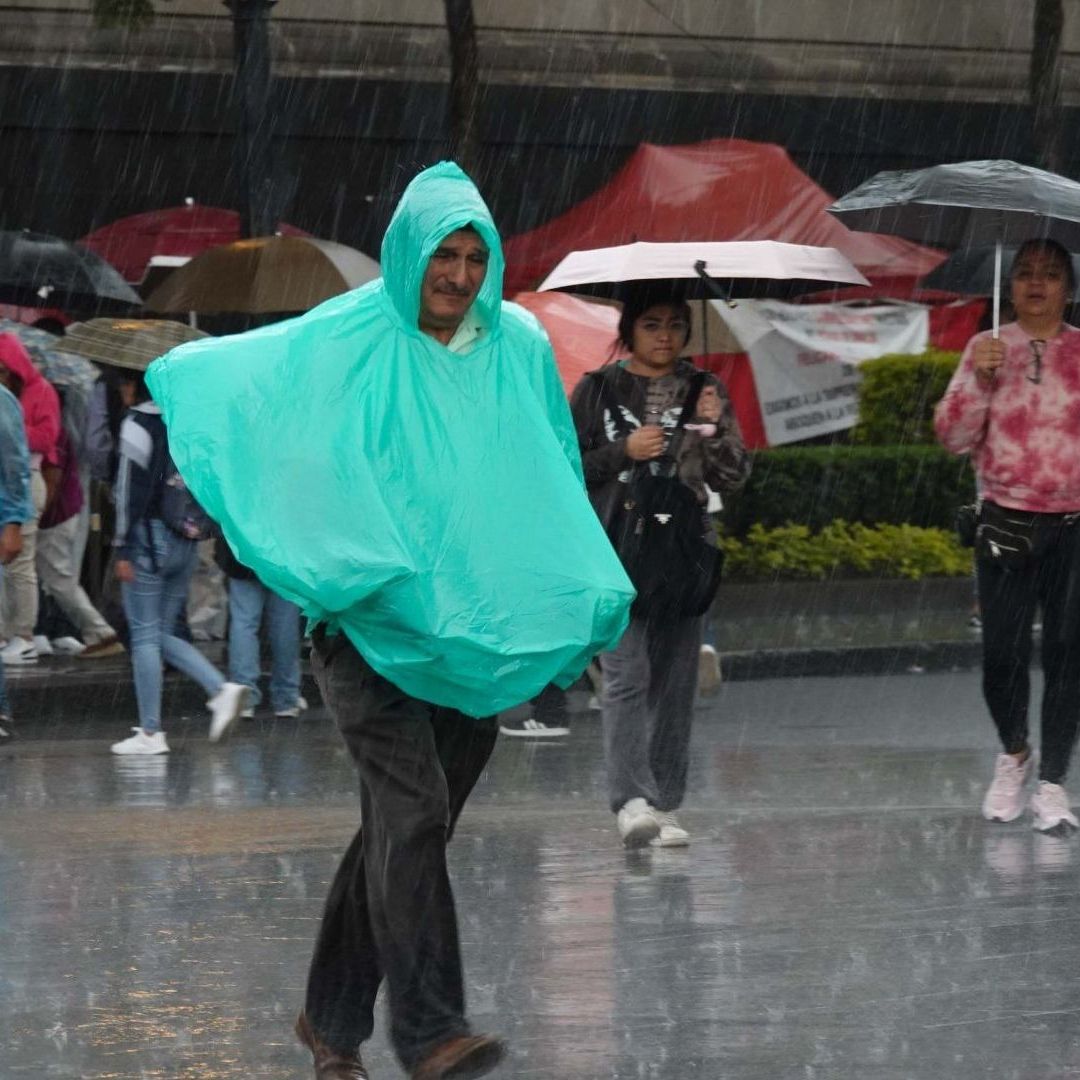 Transeúntes se cubren de las fuertes lluvias presentadas en el Centro de la capital del país