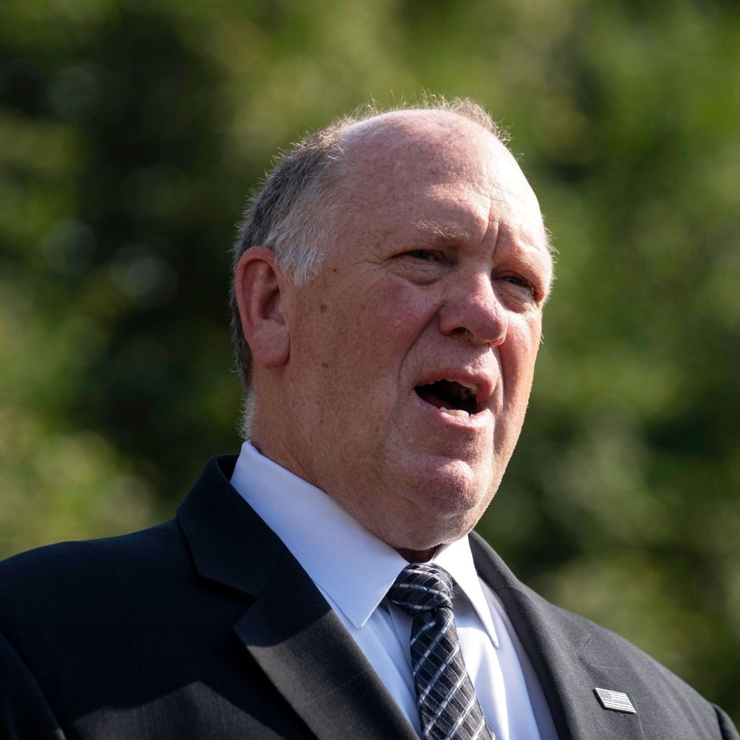 Tom Homan viste traje y corbata oscuros mientras habla