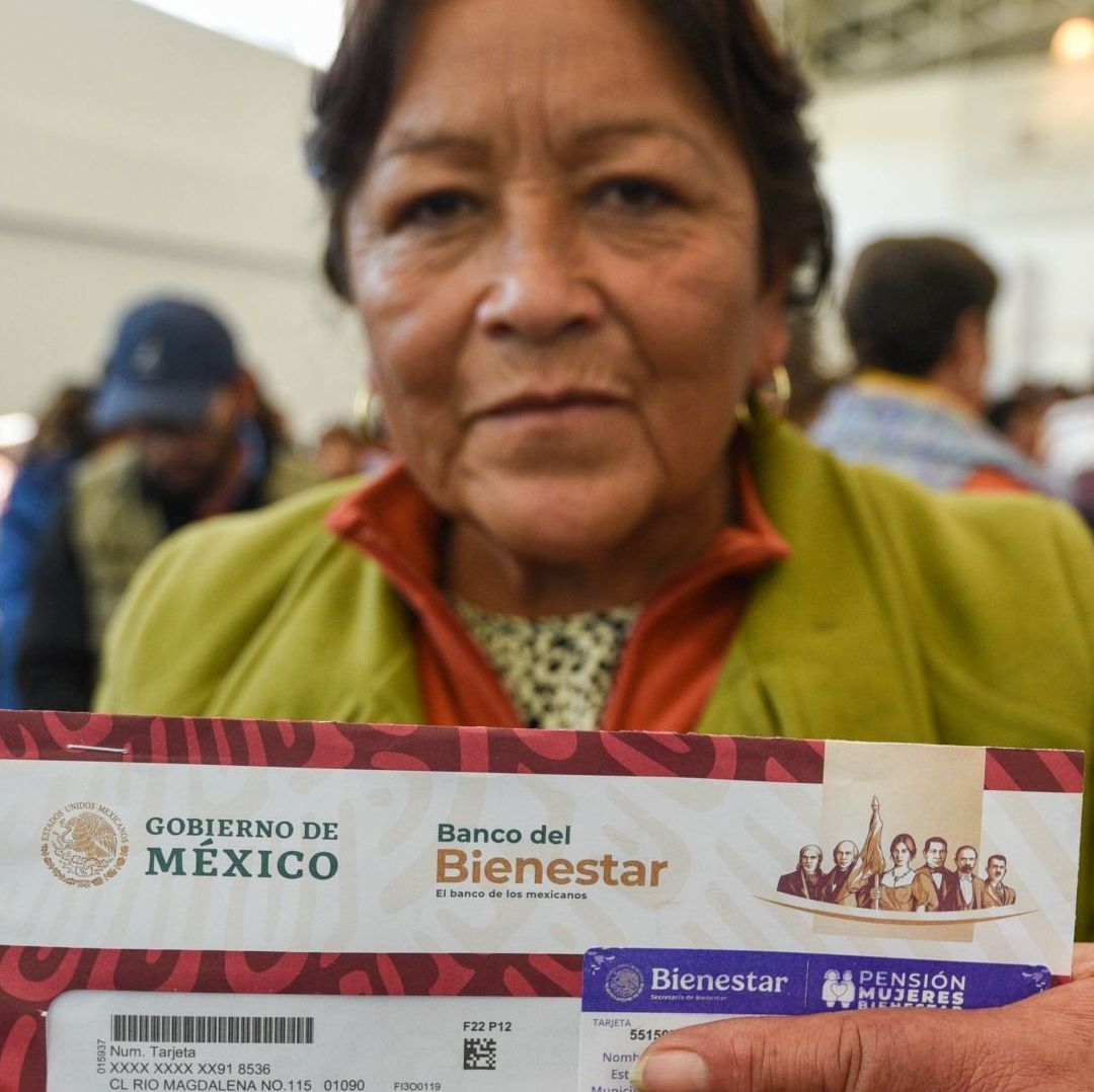 Mujer muestra tarjeta de la Pensión Mujeres Bienestar