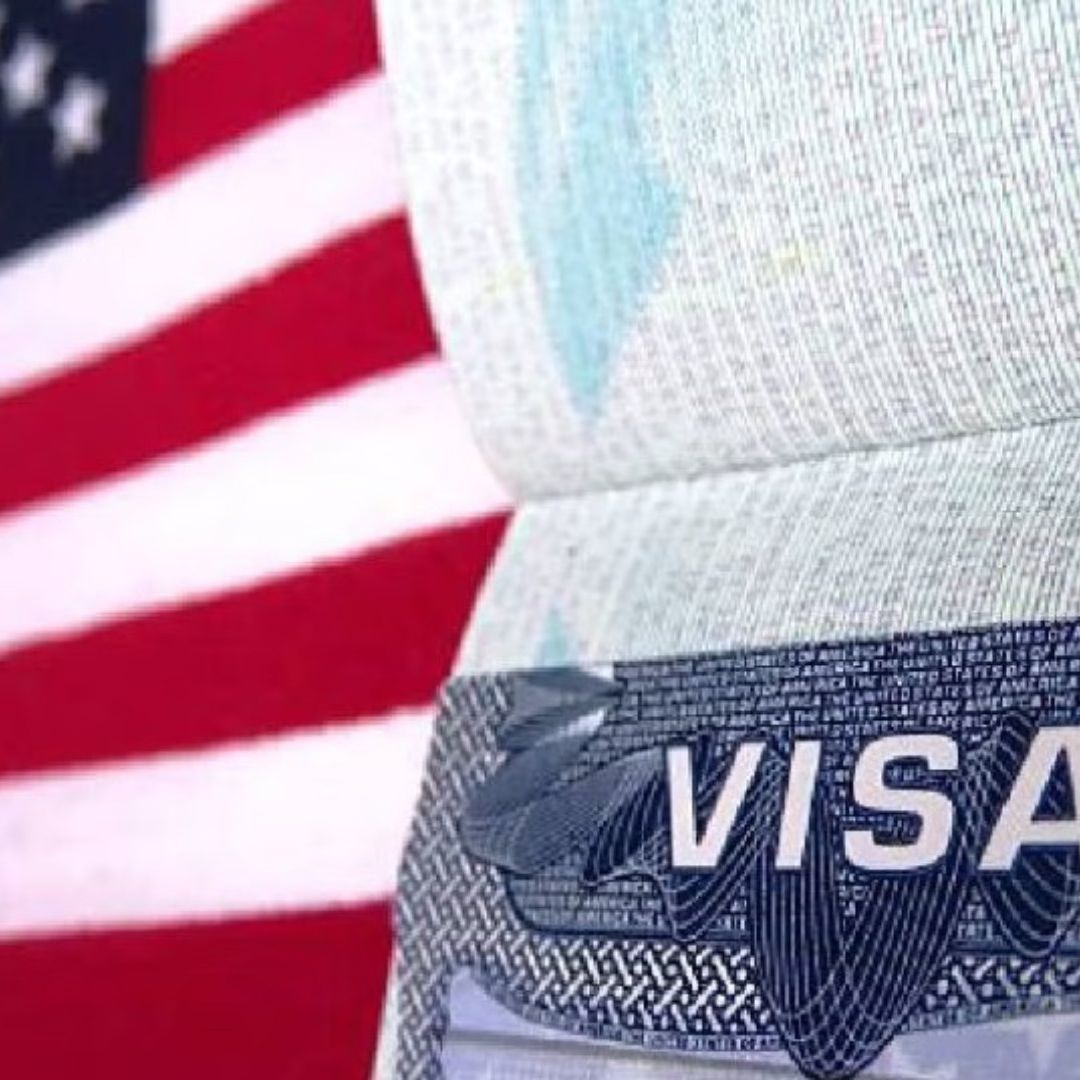 Imagen de una bandera de Estados Unidos junto con una visa americana.