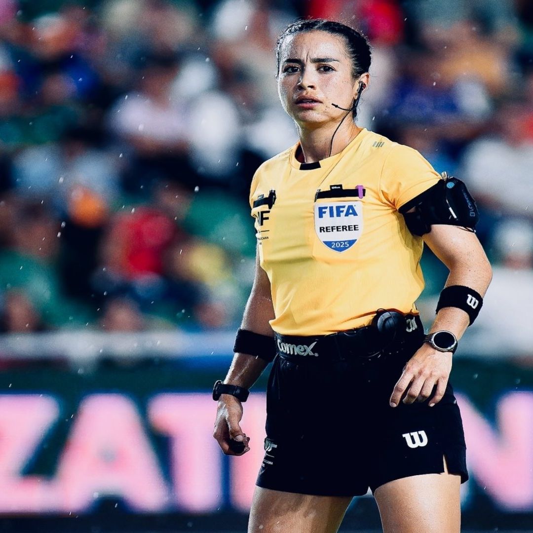 Katia Itzel García, arbitra mexicana, durante un partido. Usa uniforme amarillo con negro.