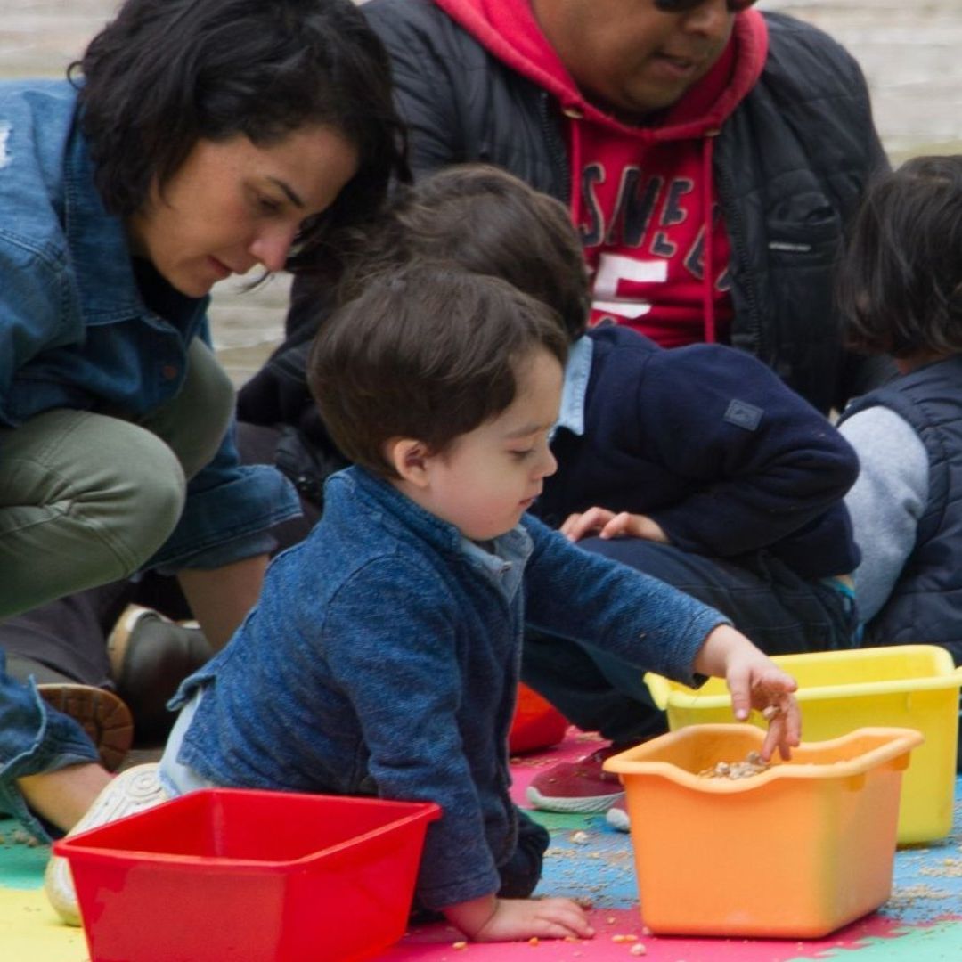 Personas juegan con niños en un espacio abierto