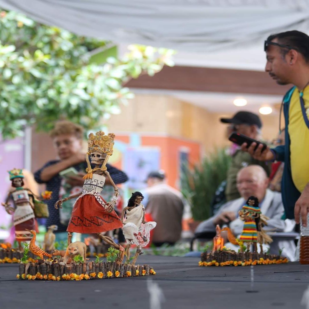 Personas observando una pfrenda temática de Día de Muertos.