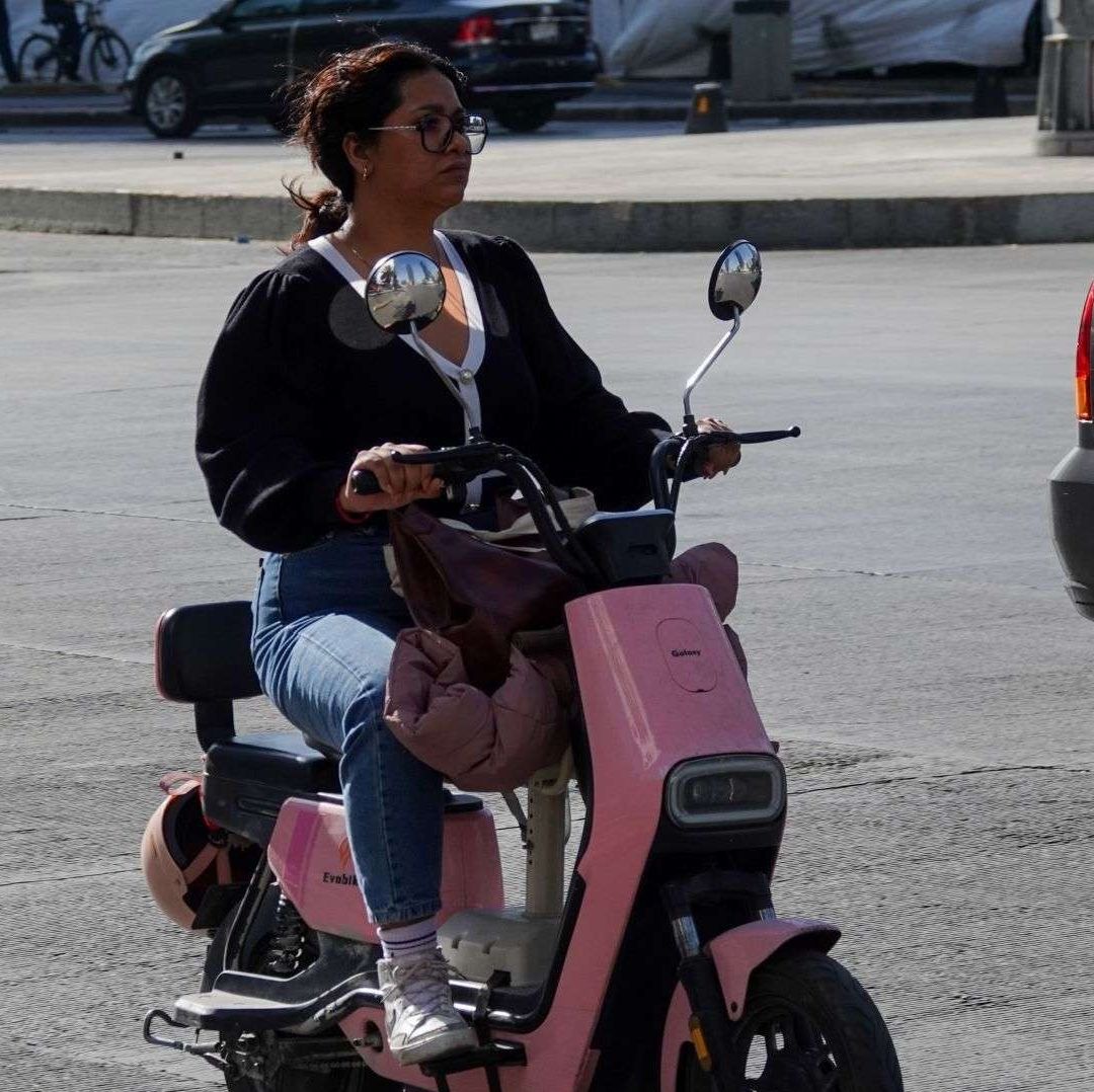 Una mujer abordo de una bicicleta de color rosa.