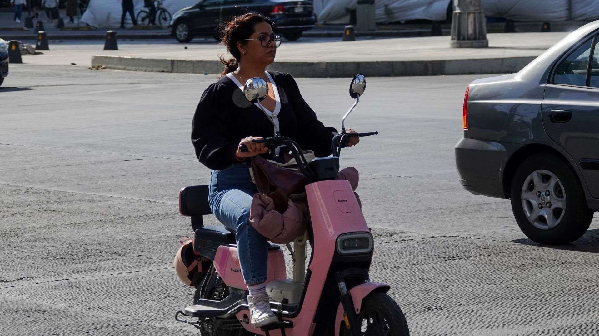 Una mujer abordo de una bicicleta de color rosa.