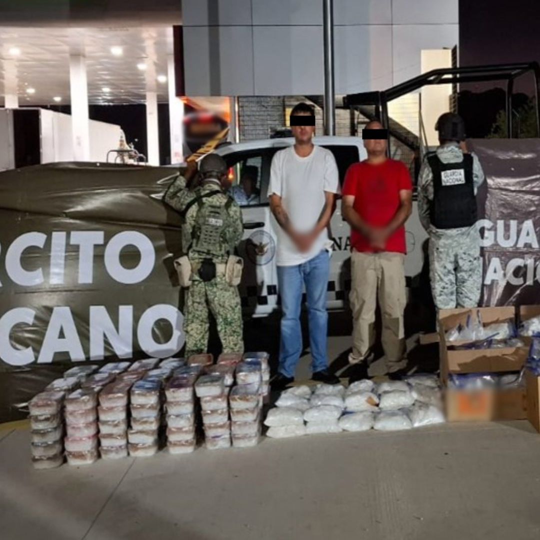 Dos personas detenidas frente a paquetes decomisados, junto a ellos hay personal del Ejército Mexicano.