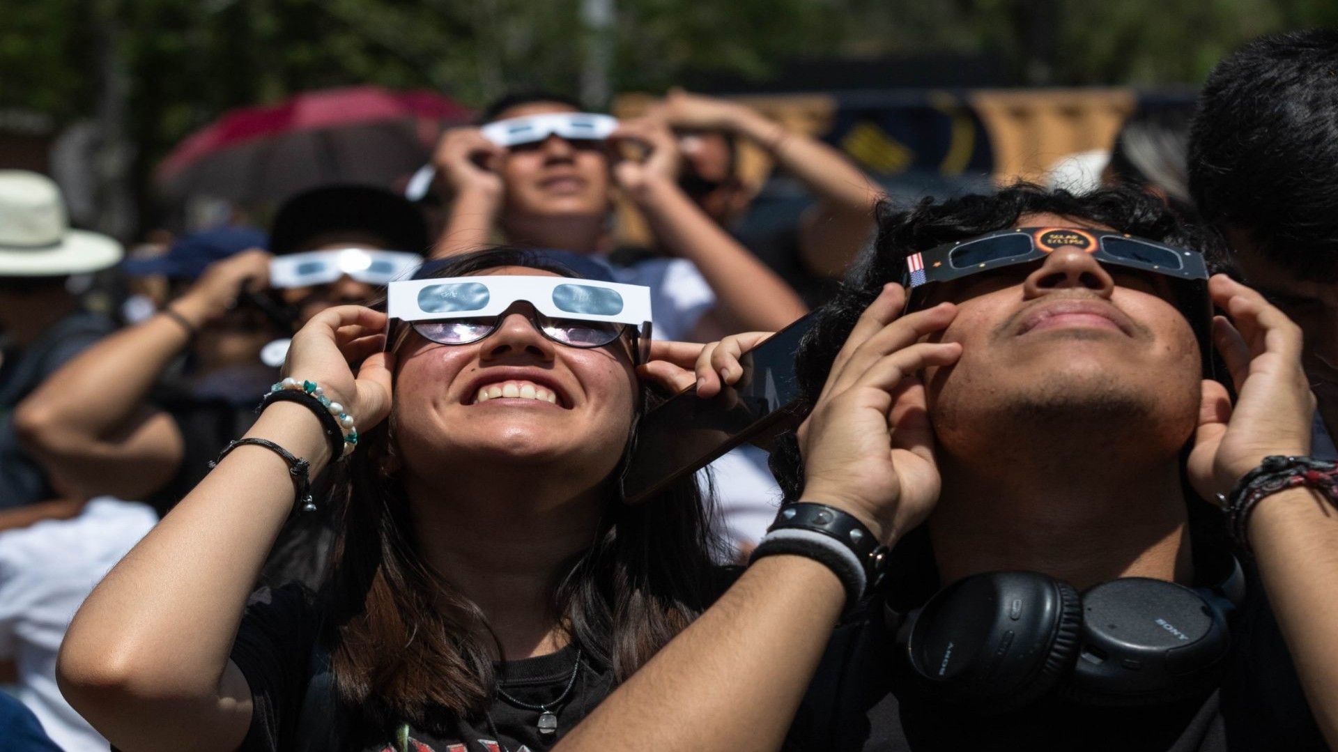 Varias personas utilizan lentes certificados para ver eclipse solar.