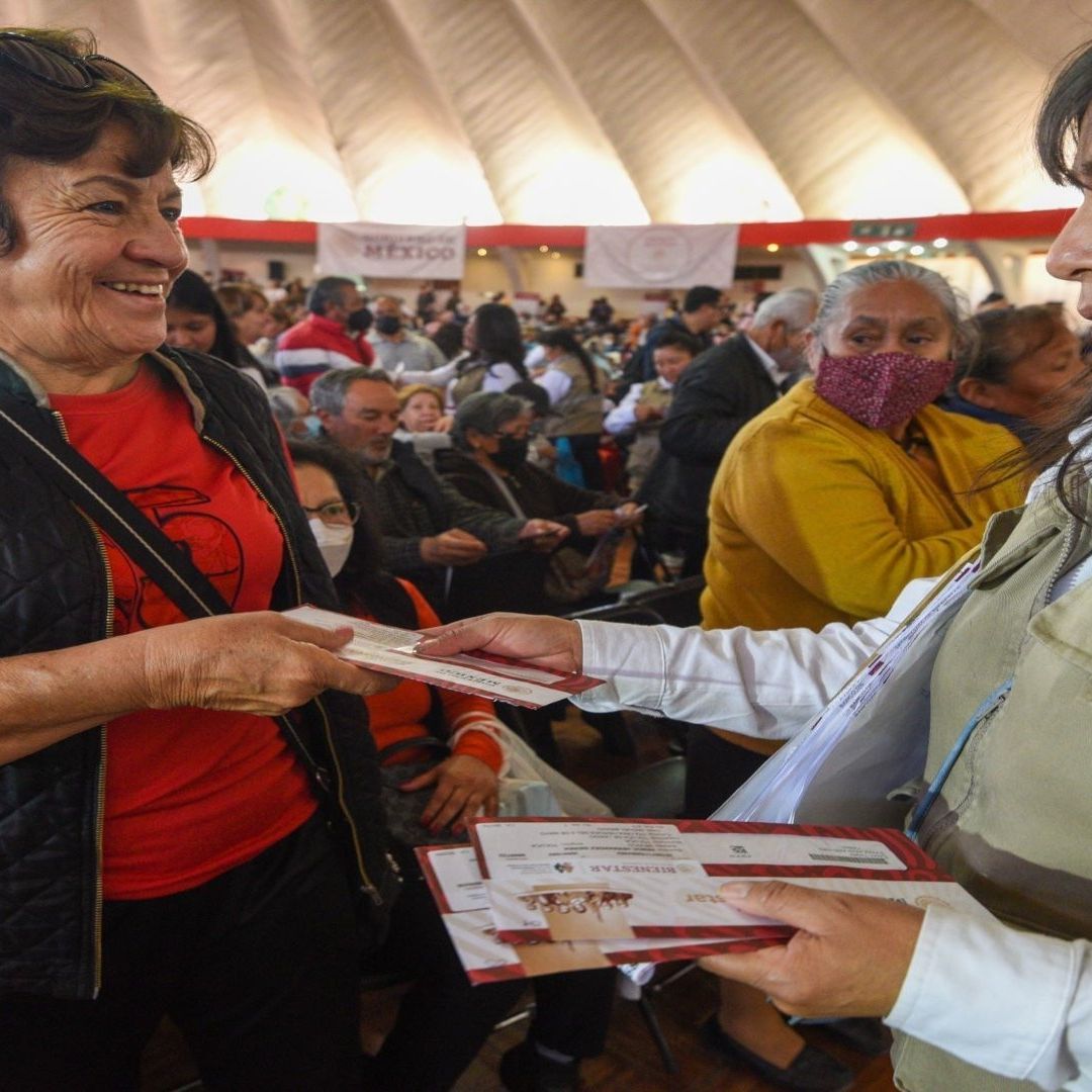 Una mujer le entrega una tarjeta a una adulta mayor.