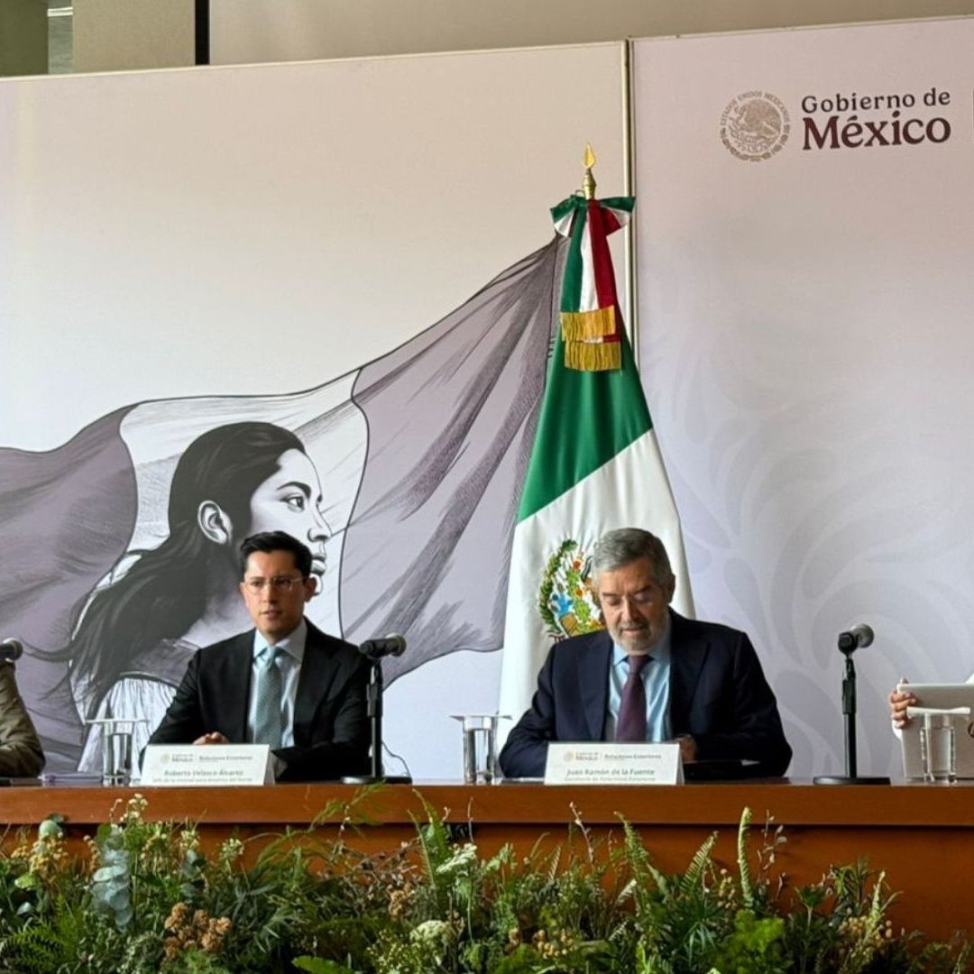 Tres personas en conferencia de prensa.