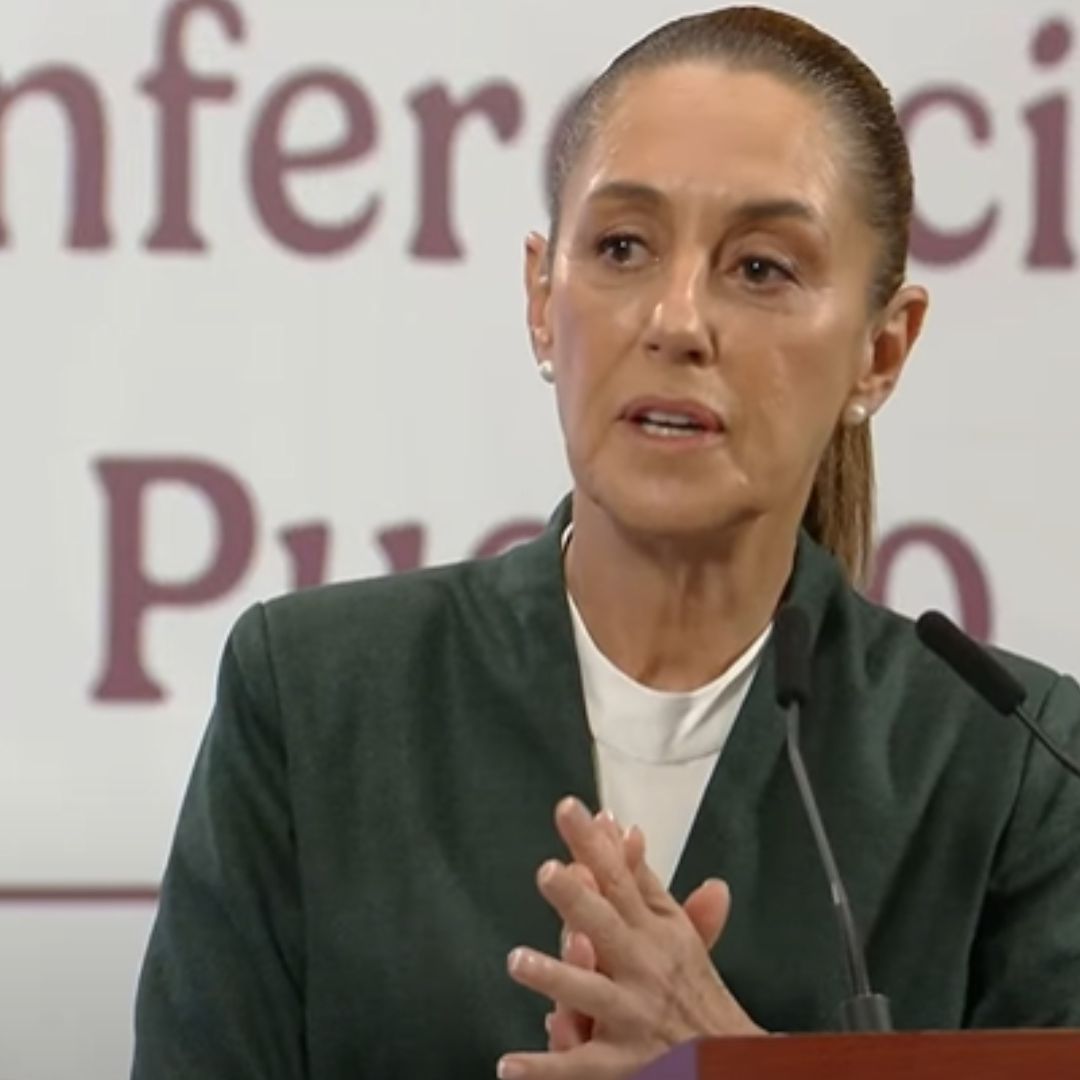 Una mujer viste de color verde con blanco, atrás hay unas letras.