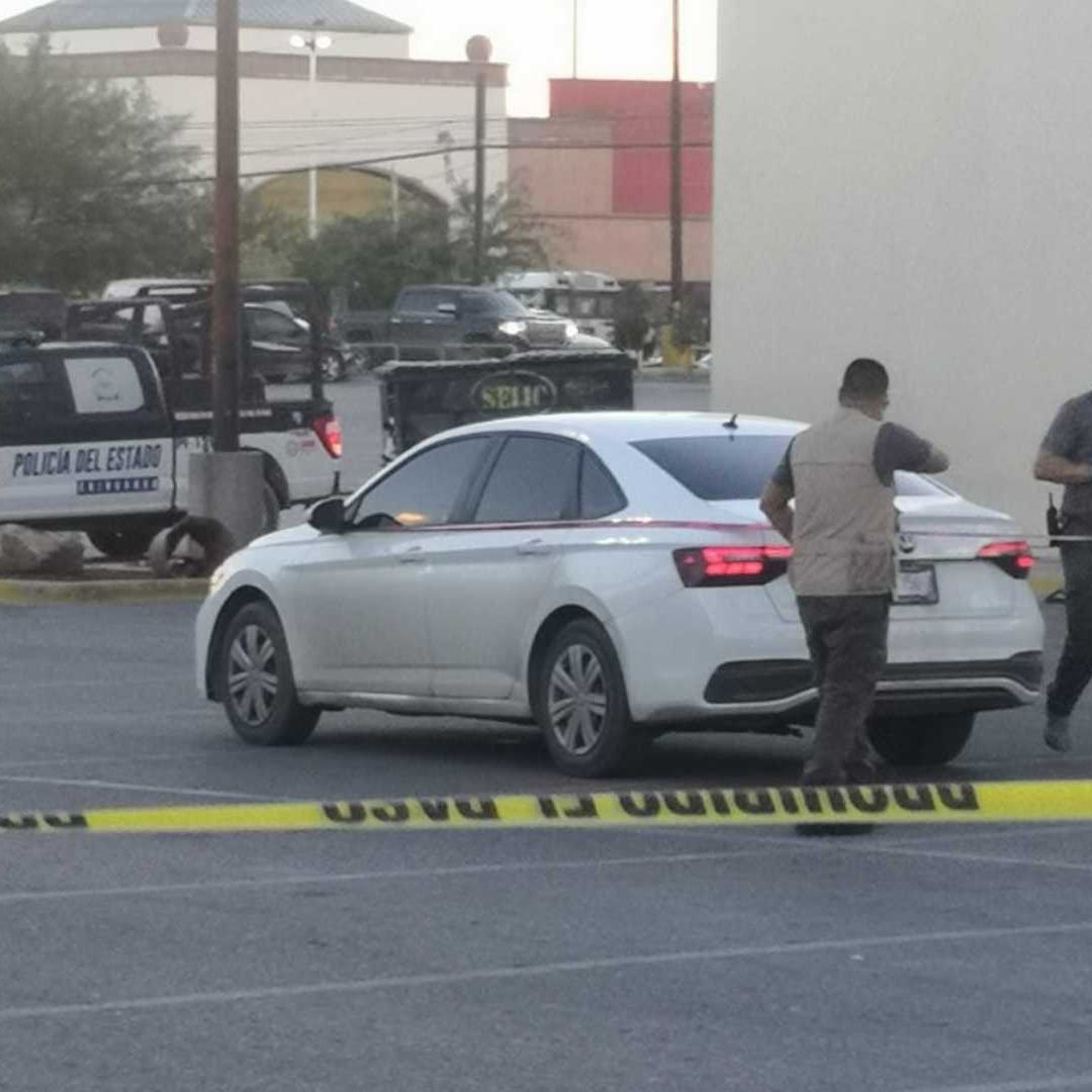 Elementos de seguridad acordonando el estacionamiento de la plaza comercial.