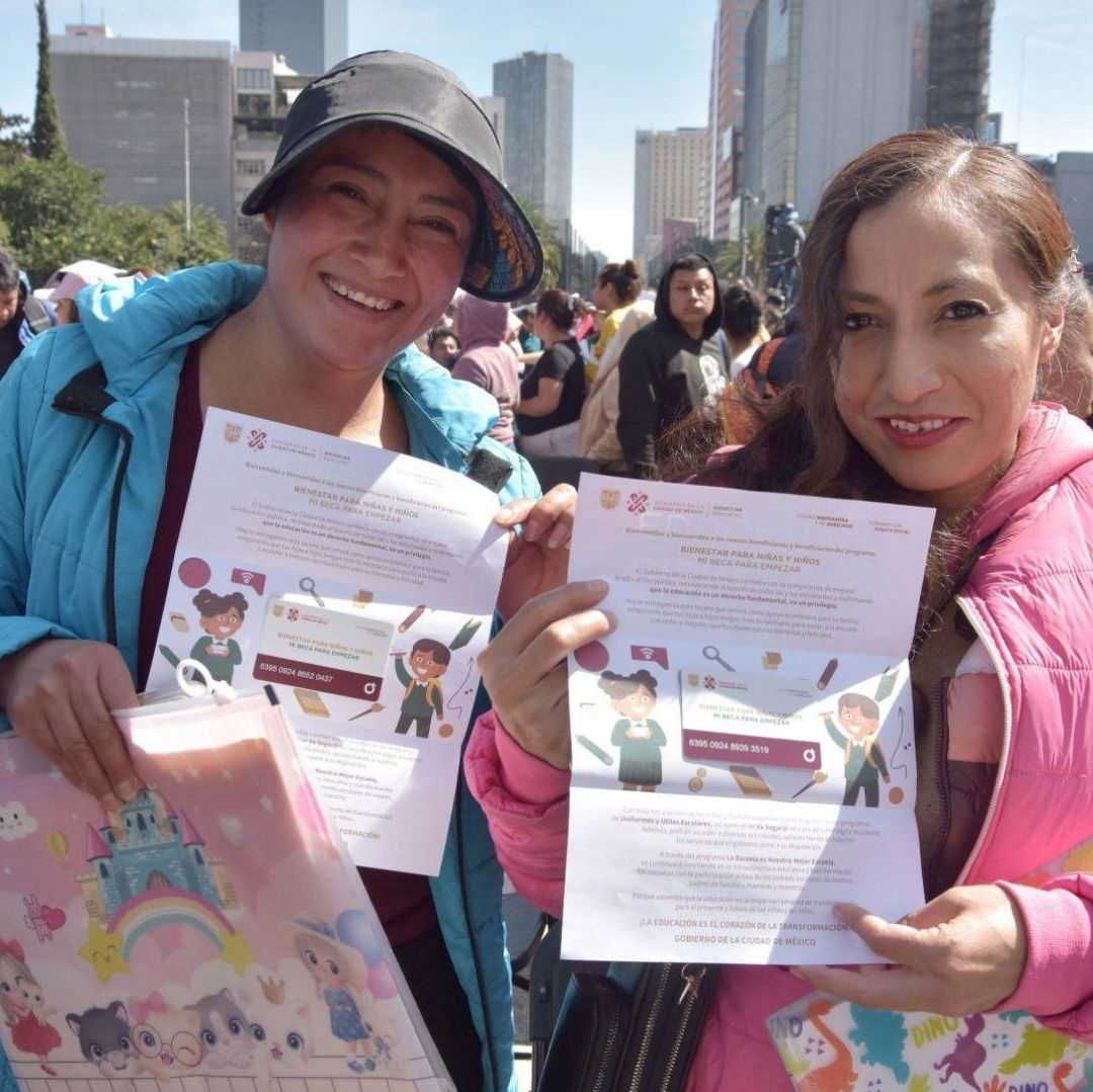 Dos mujeres muestran tarjetas que tienen ilustraciones de niños.