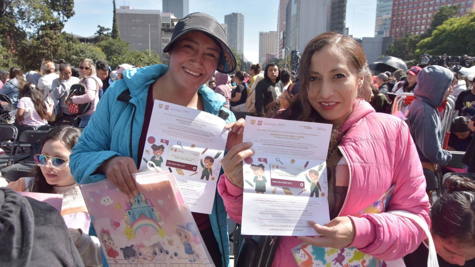 Dos mujeres muestran tarjetas que tienen ilustraciones de niños.