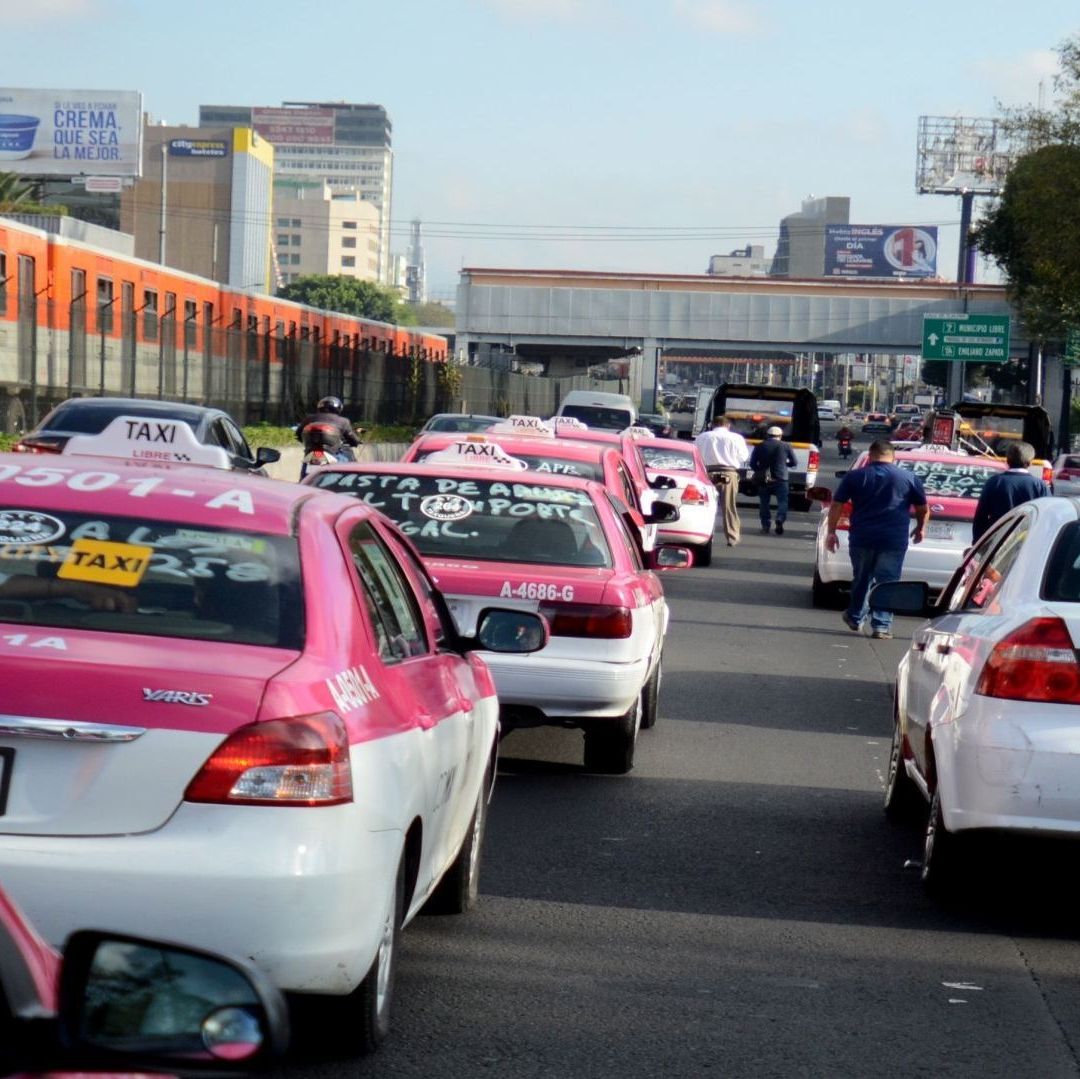 Carros de color blanco con rosa están detenidos en medio del tránsito.
