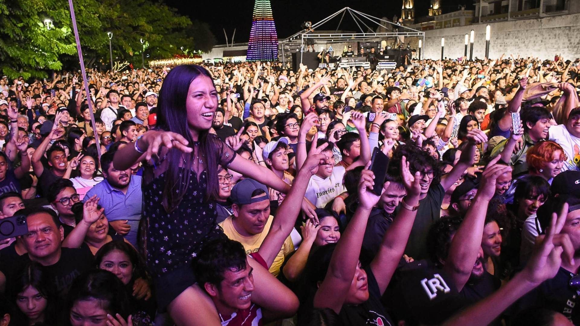 Varias personas disfrutando de un concierto, se muestran felices y efusivas.