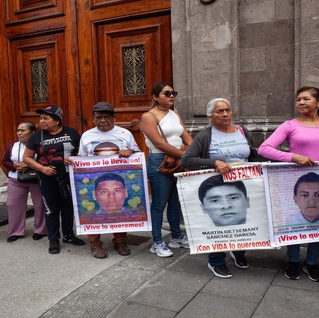 Padres de familia protestan con carteles de sus hijos.